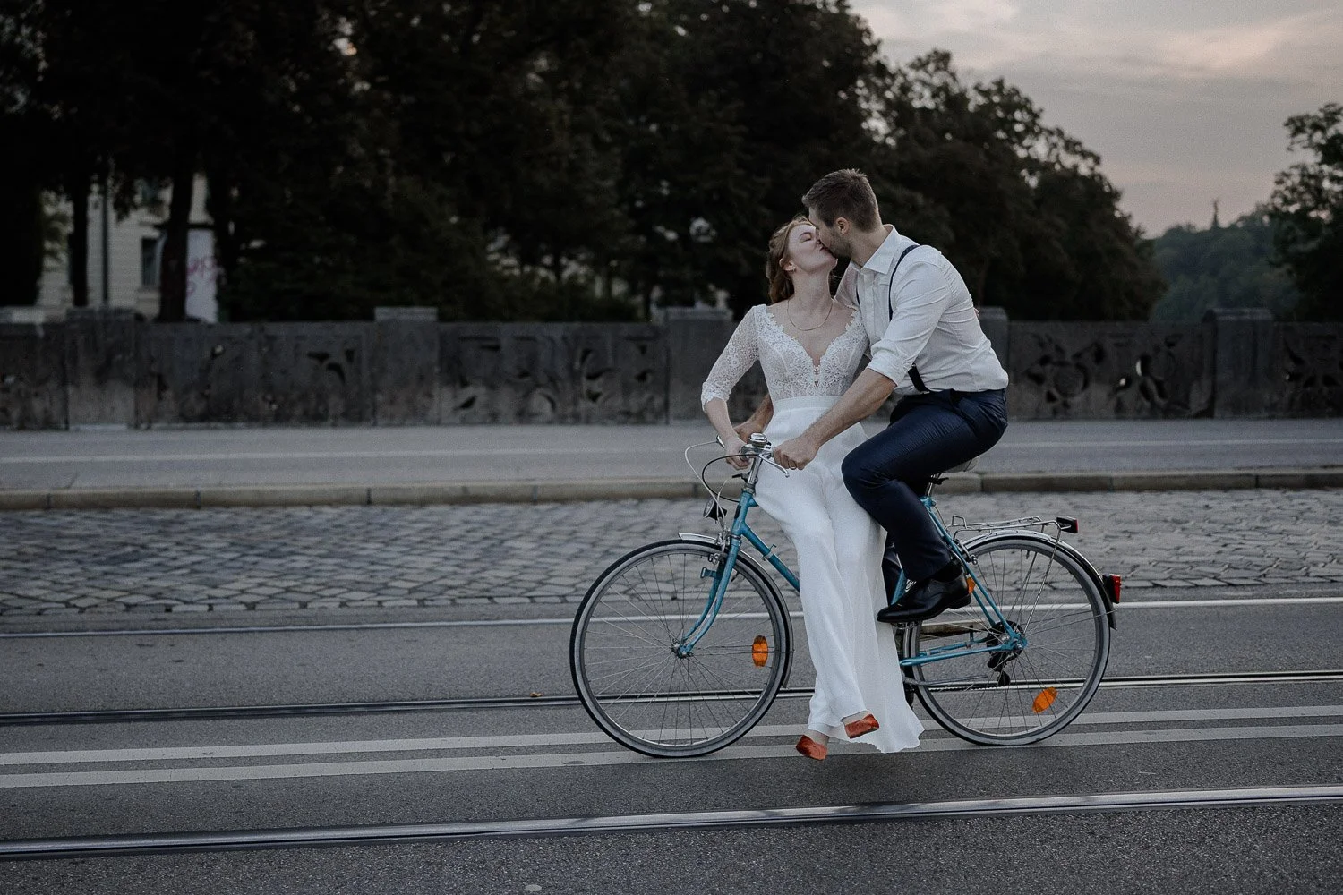 Paar Fotoshooting München auf Fahrrad mit Kuss auf leerer Straße