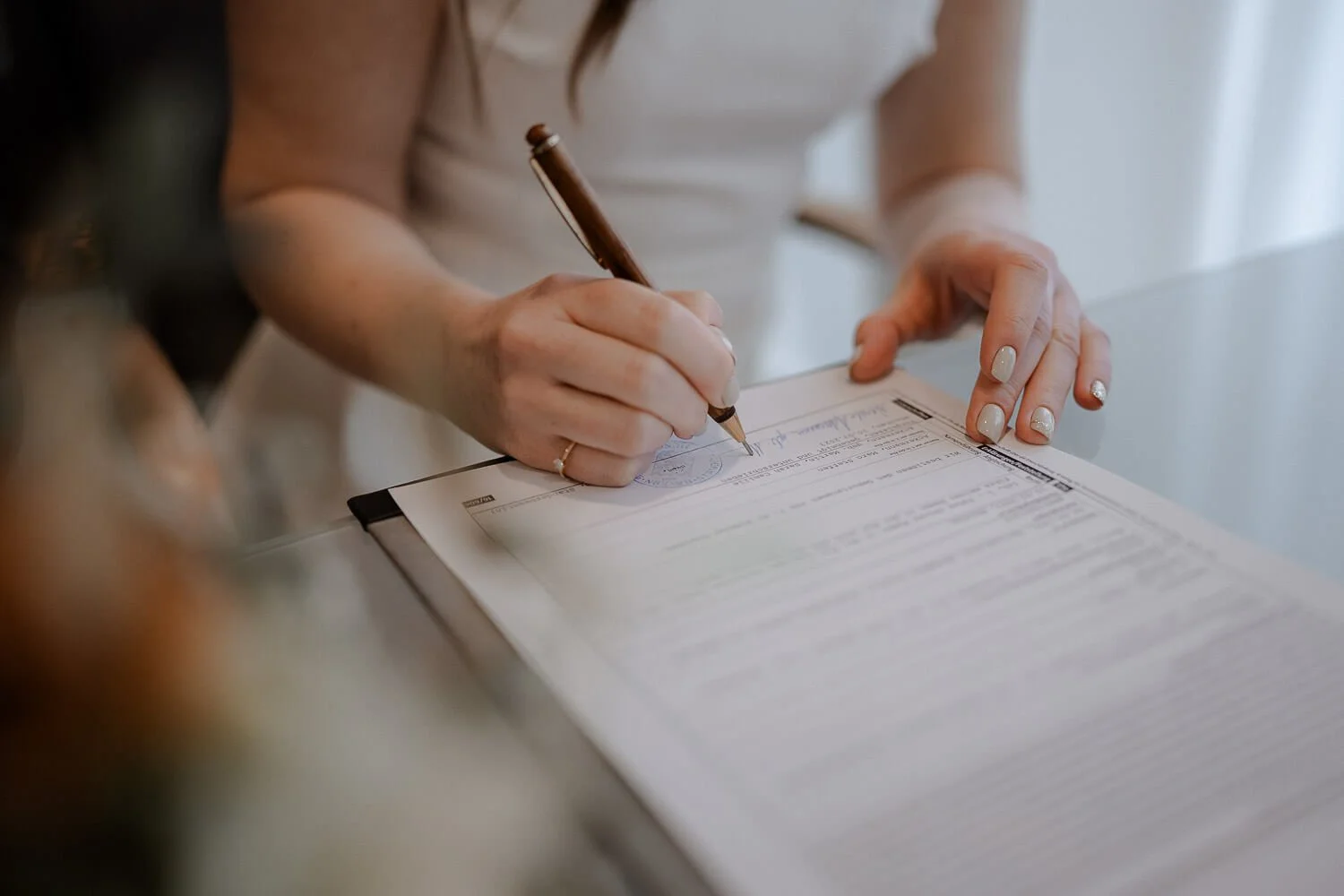 Braut unterschreibt Heiratsurkunde im Standesamt München Pasing