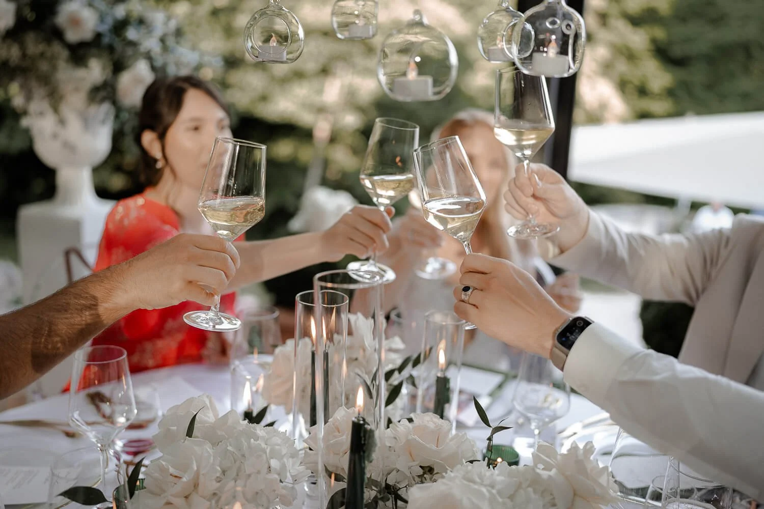 Gäste stoßen mit Weißwein bei Hochzeit im La Villa am Starnberger See an