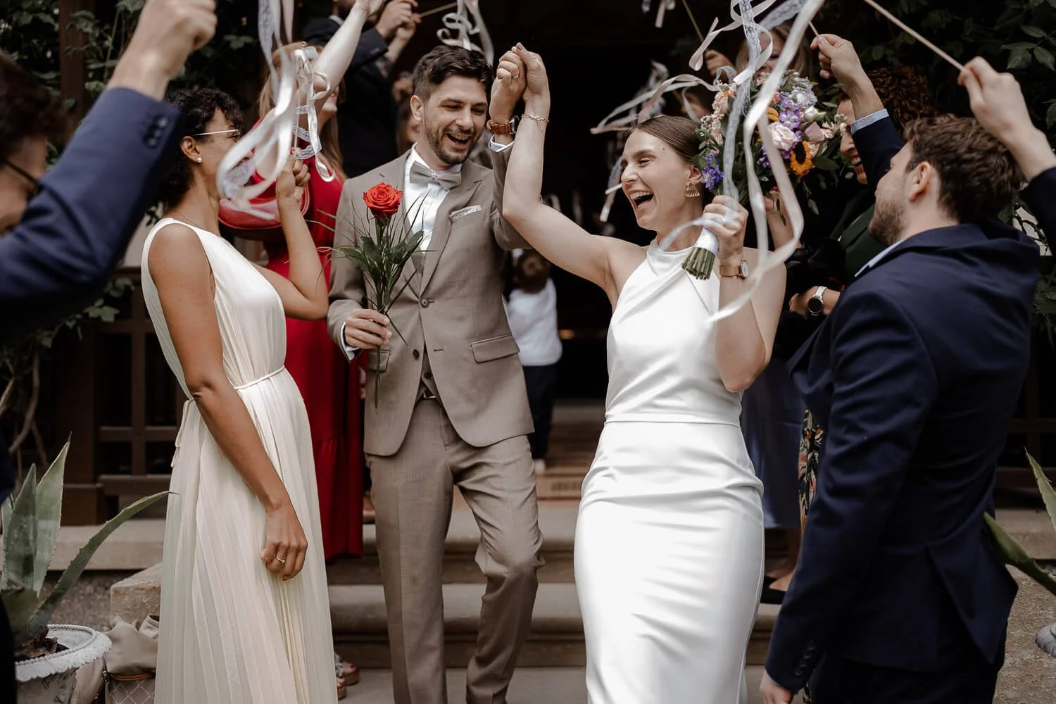 Spalier &amp; Feiern nach der Trauung (Brautpaar lacht, Blumenstrauß, Bänder) – roseninsel hochzeit feiern