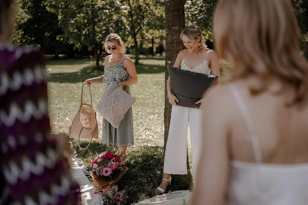 Nach der Trauung: Braut mit Kissen bei Picknick im Grünen in München