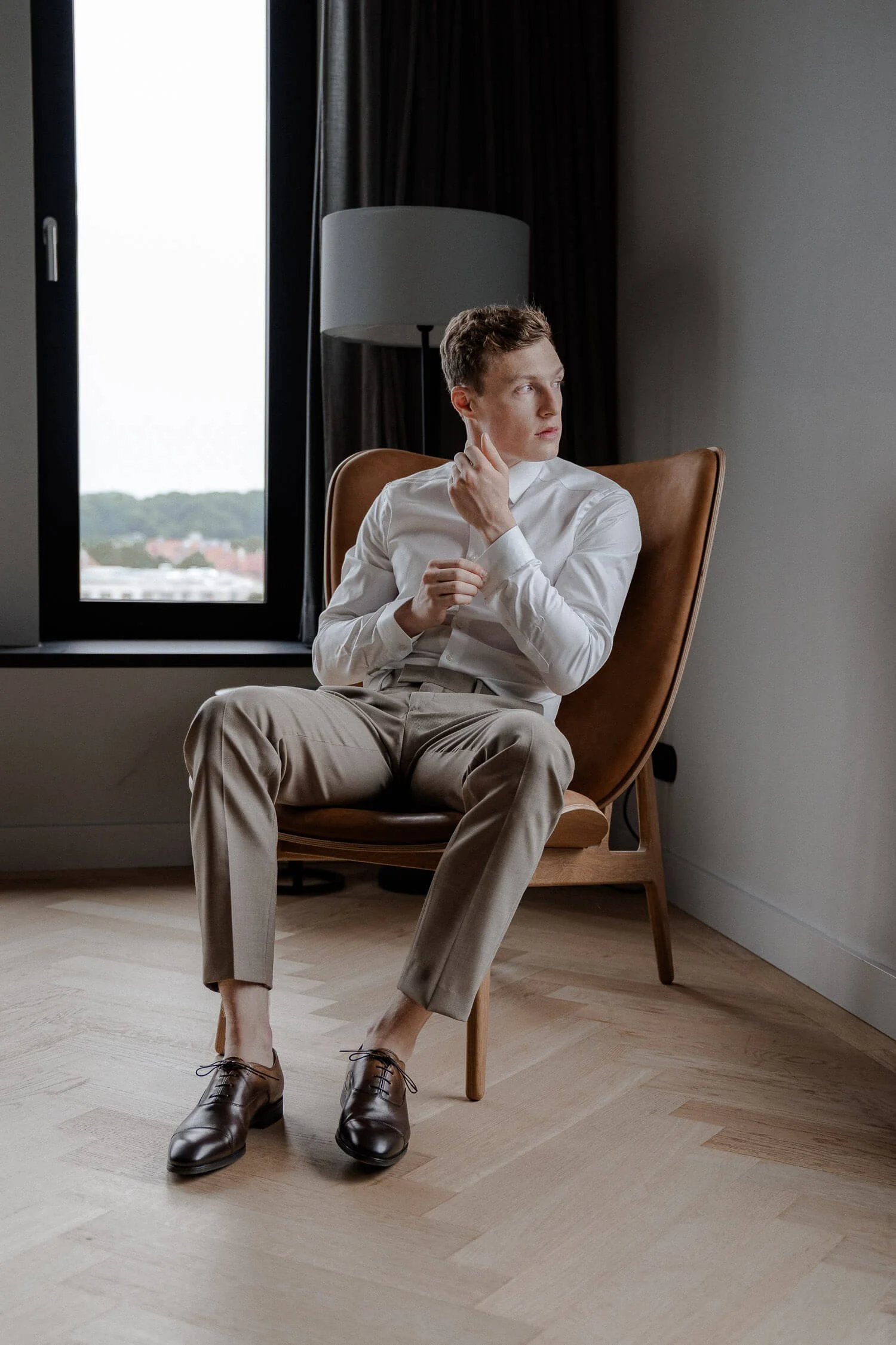 Bräutigam sitzt am Fenster im andaz munich schwabinger tor