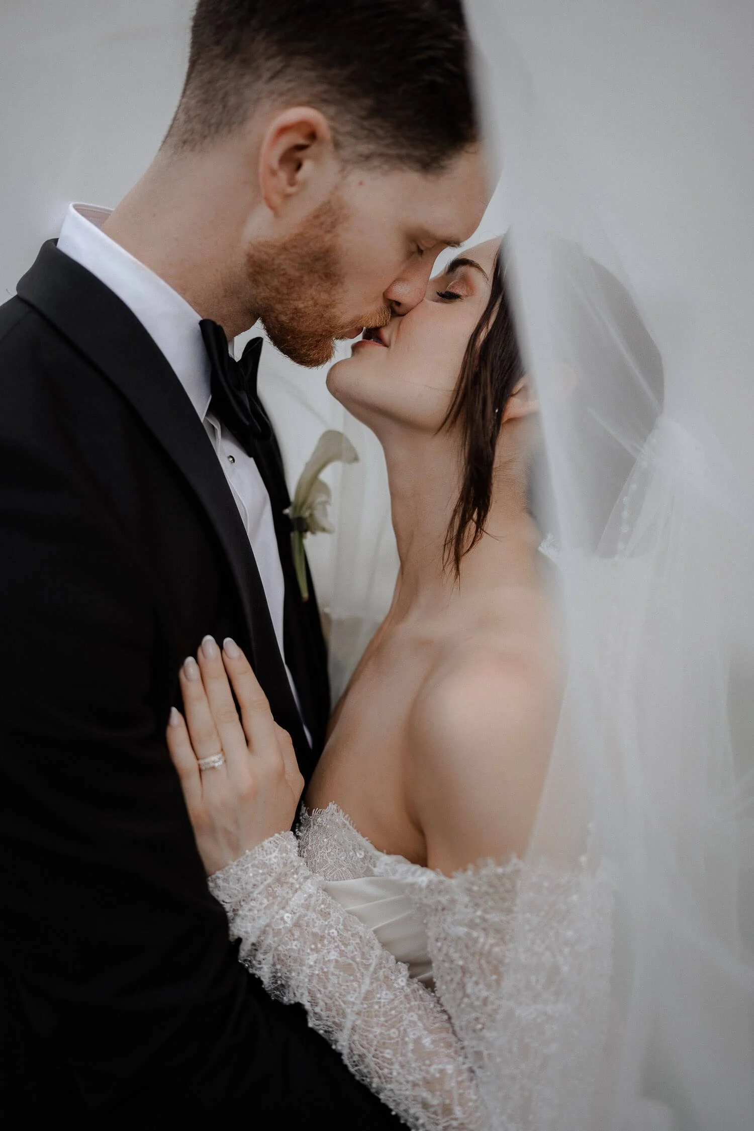 Inniger Schleierkuss des Brautpaars bei Hochzeit.