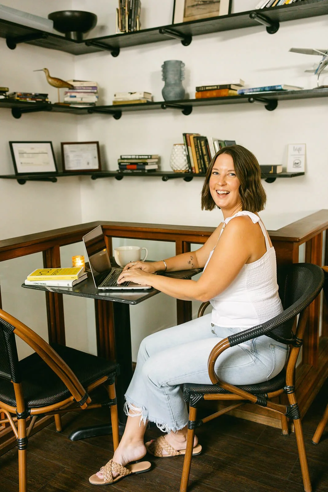 Polly, a blog writer, typing on laptop and smiling at camera