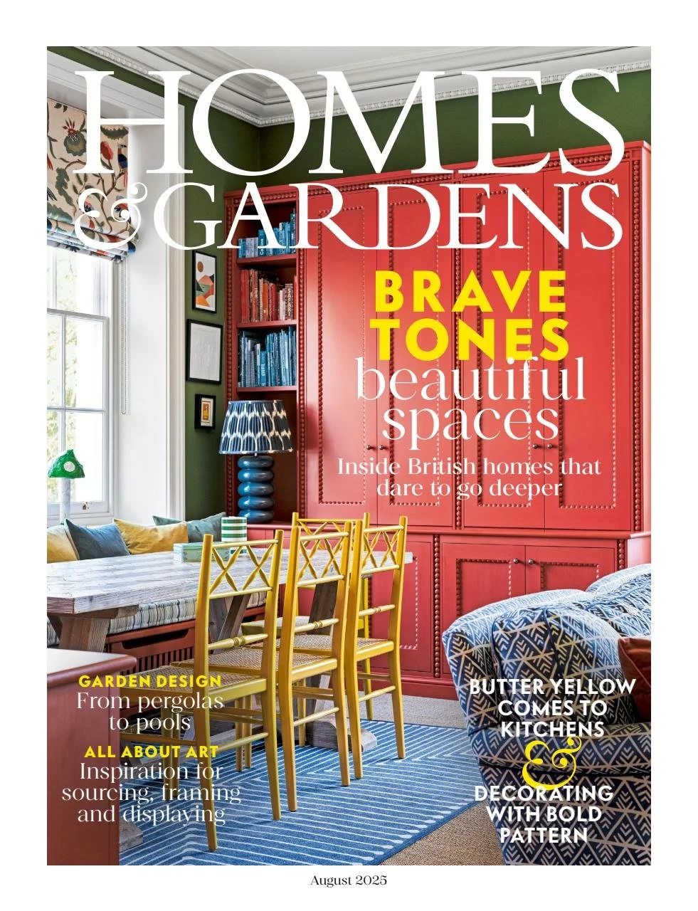 Cover of a magazine titled 'Homes & Gardens' with headlines about interior design, featuring a colorful room with a green wall, a red cabinet, a blue and white patterned sofa, and a yellow dining set in front of a blue striped rug.