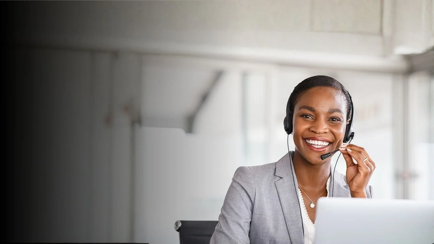 Client support specialist on phone and computer smiling
