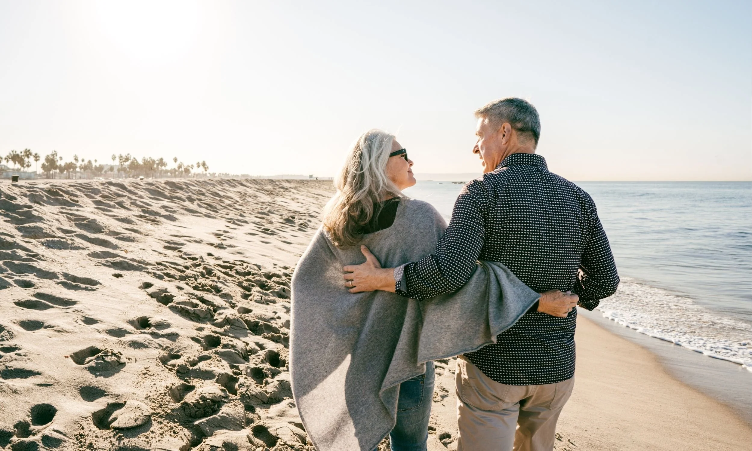 Retired executives walking on beach