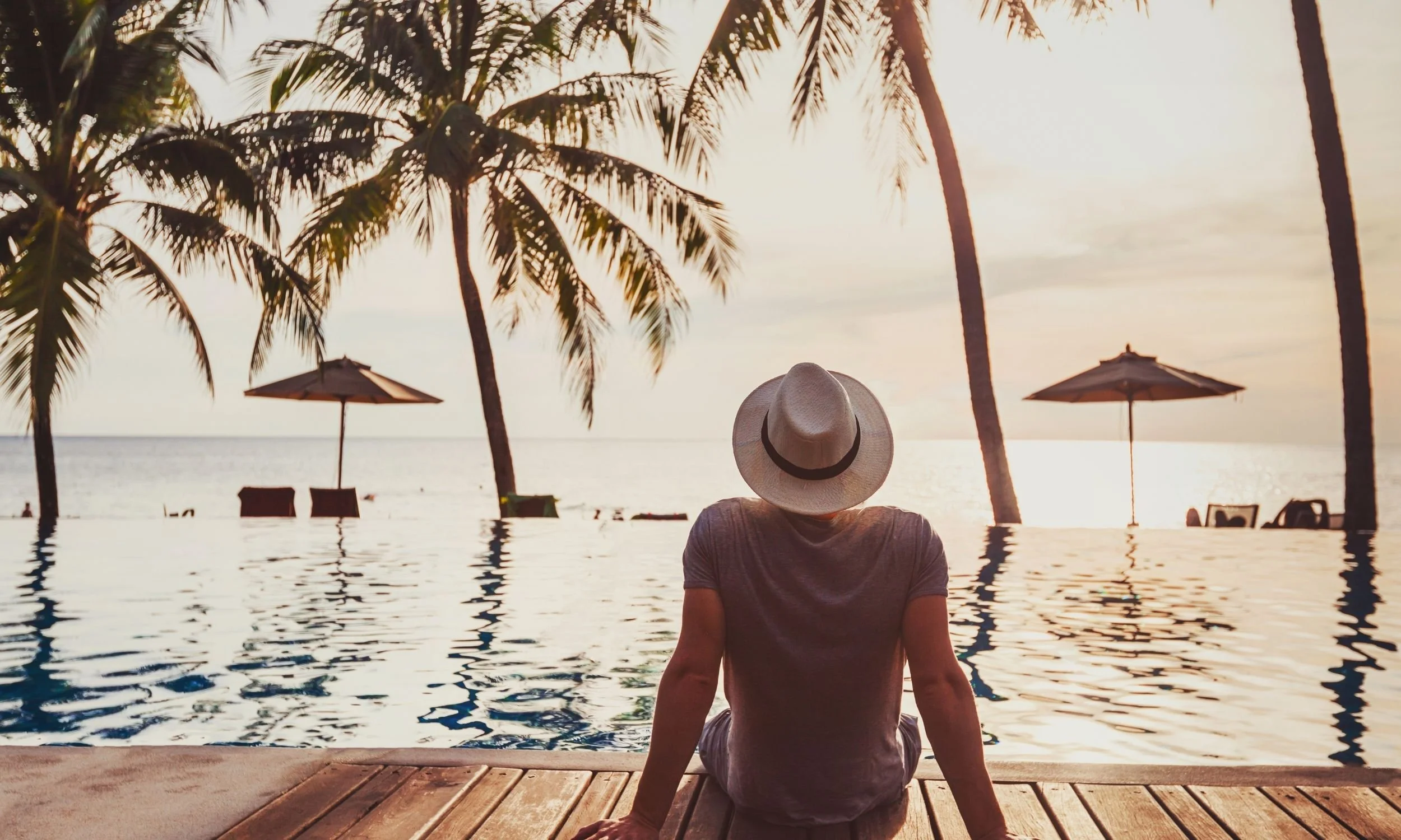 Man relaxing by pool on vacation