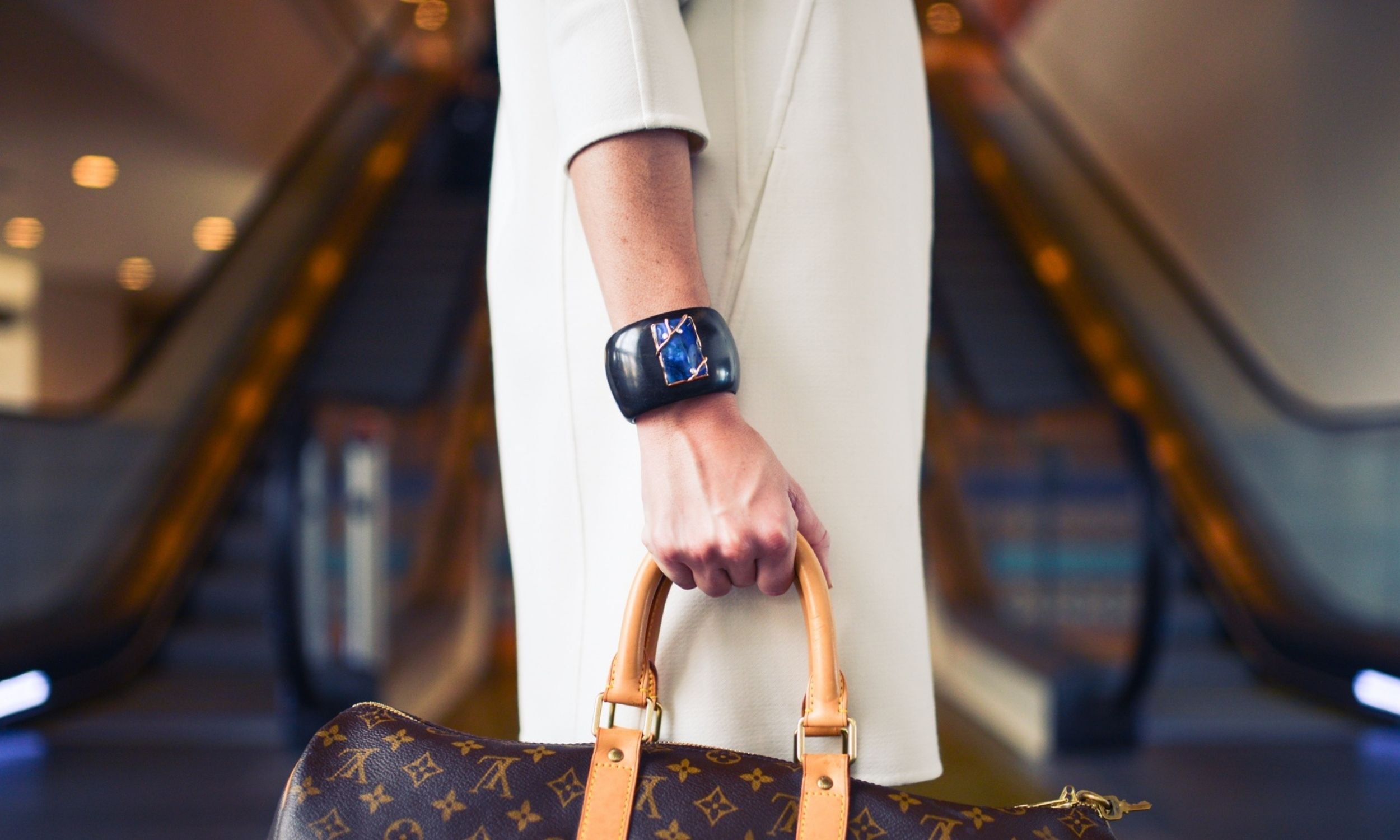 Woman's hand holding Louis Vuitton bag