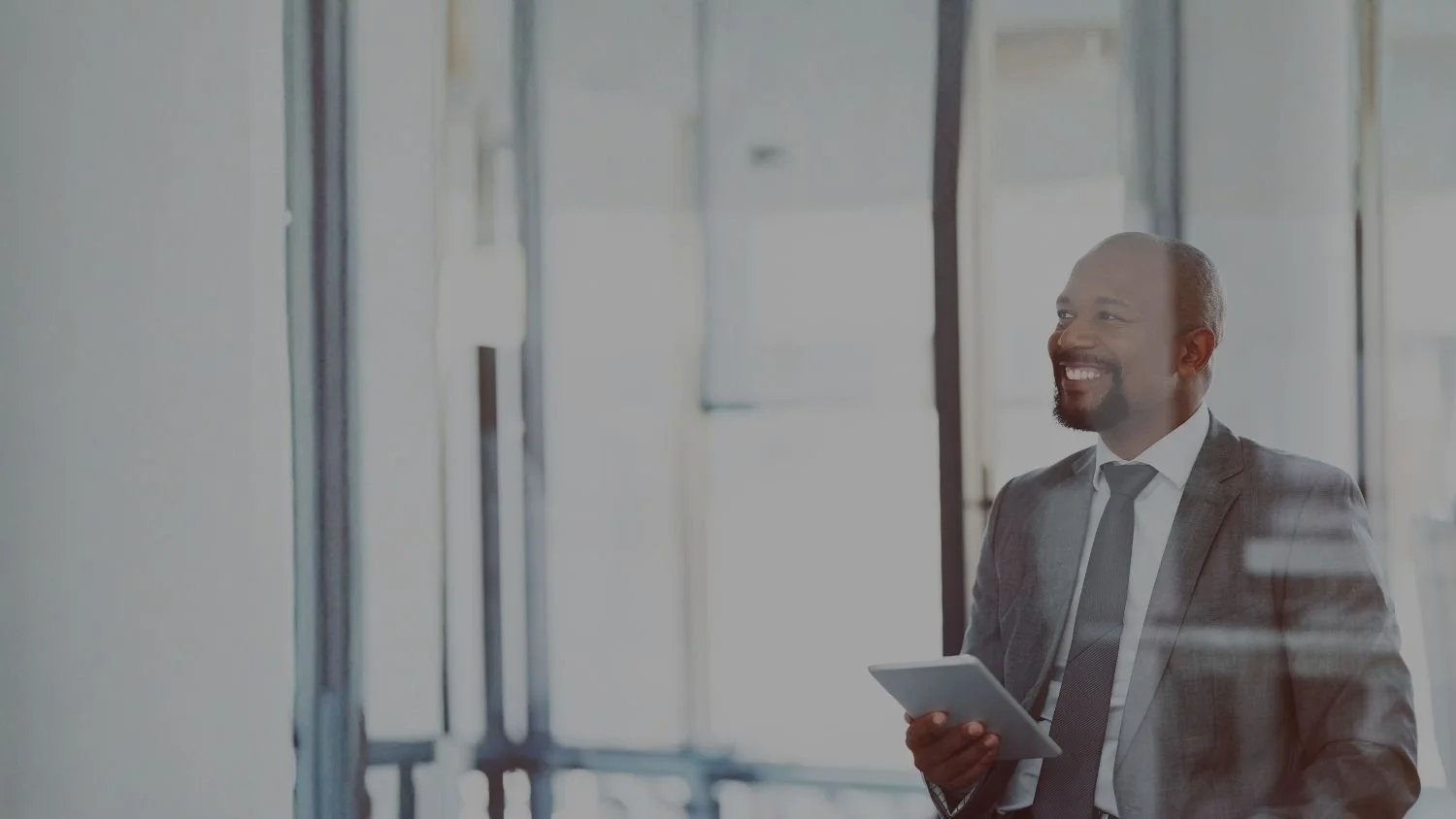 Executive on tablet smiling