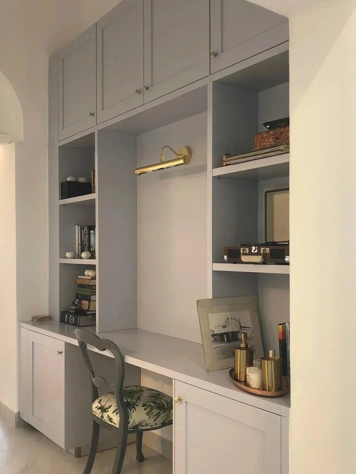 Blue Duco sprayed custom cabinets for home study, decorated with books, photo frame, and decorative items.