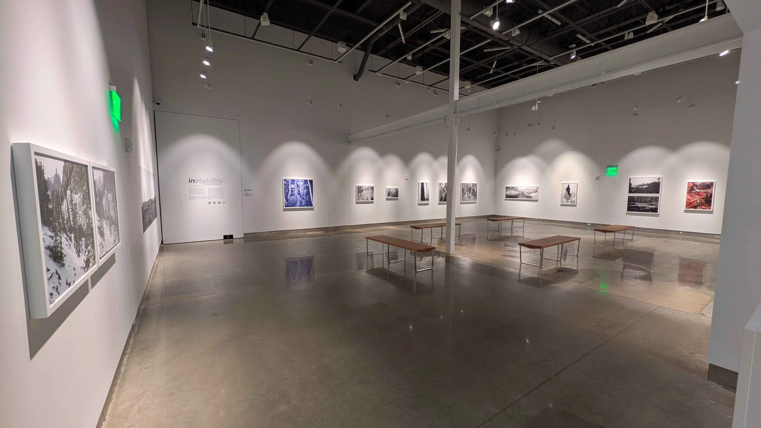A wide shot of the lacalle chesapeake gallery. Tall white walls, a polished concrete floor, and a large metal beam running through the middle.