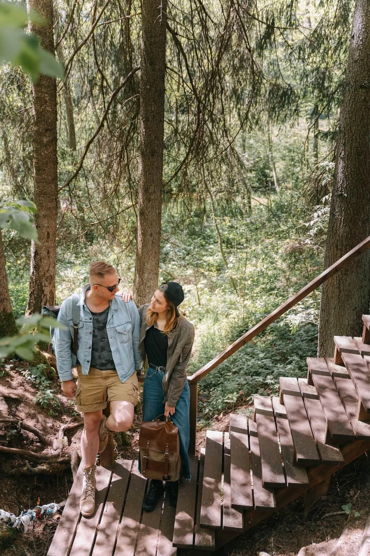 Couple standing close together on wooden steps in the forest, representing connection and relationship repair skills in St. Paul, MN, supported by a religious trauma therapist in St. Paul.