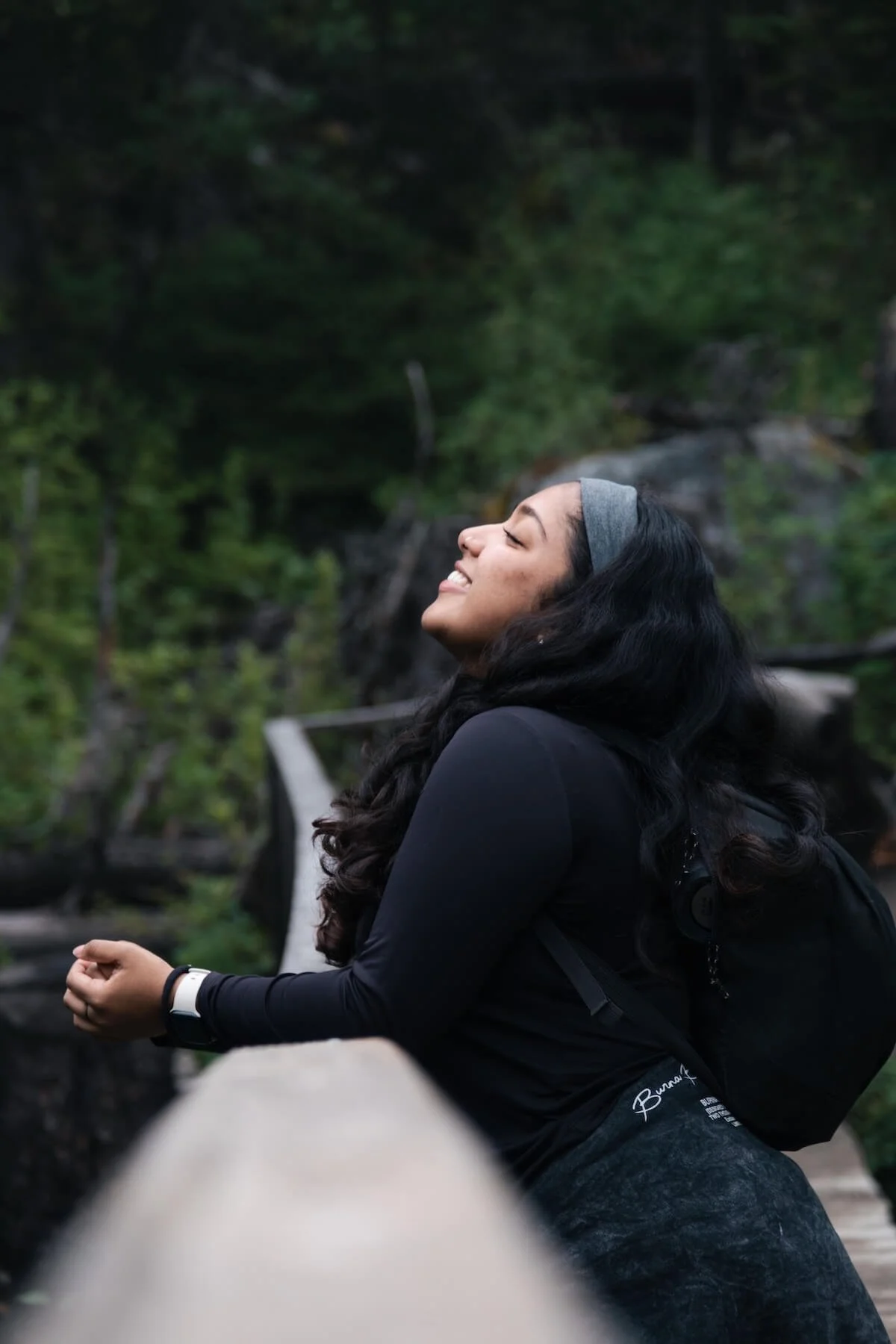 Woman smiling with her face lifted toward the sky while hiking outdoors, representing freedom and healing through religious trauma therapy and recovery from cult dynamics in St. Paul.