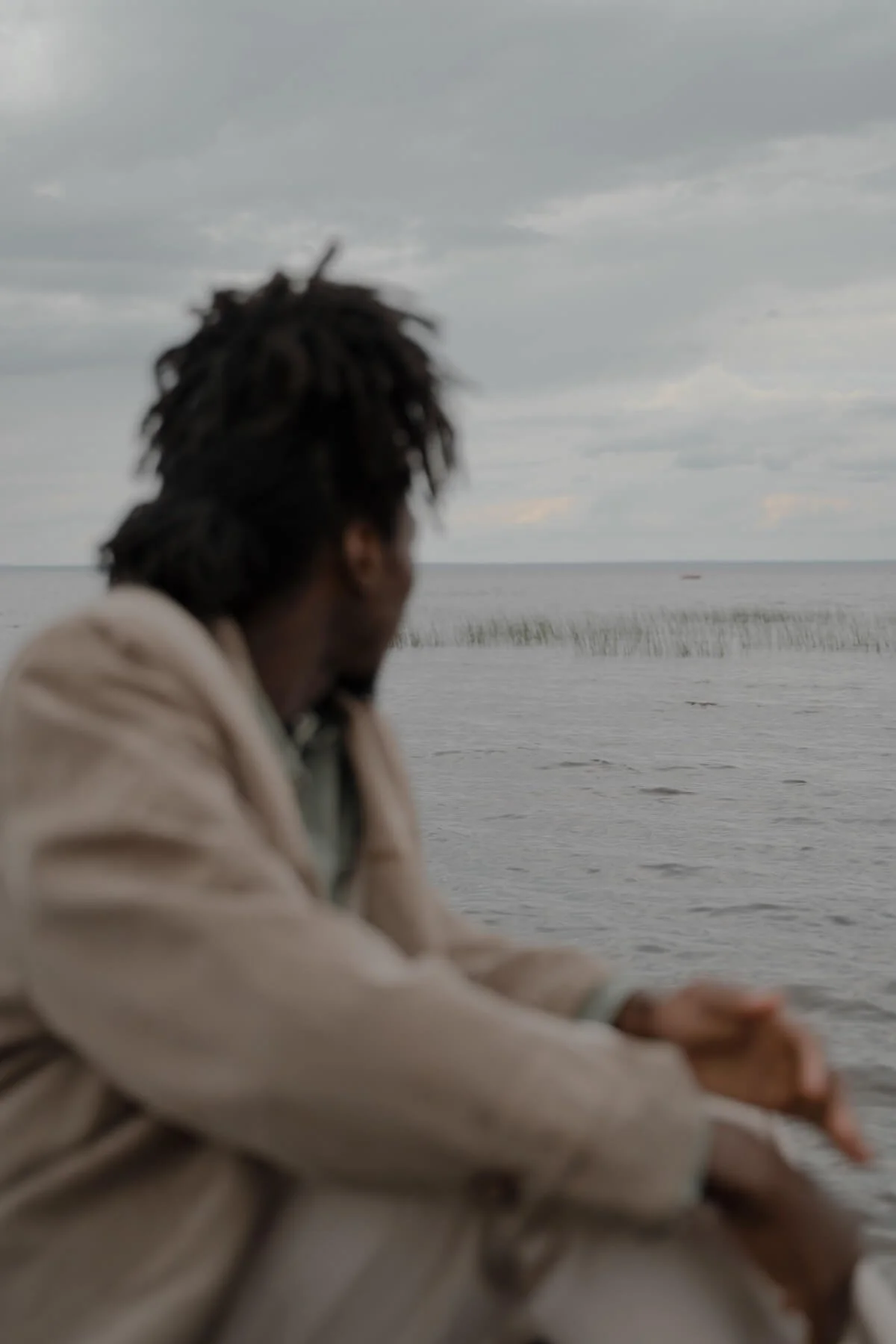 Person sitting by the water looking out at the horizon, representing the reflective work of healing through religious therapy online St. Paul, MN, with a religious trauma therapist in St. Paul.