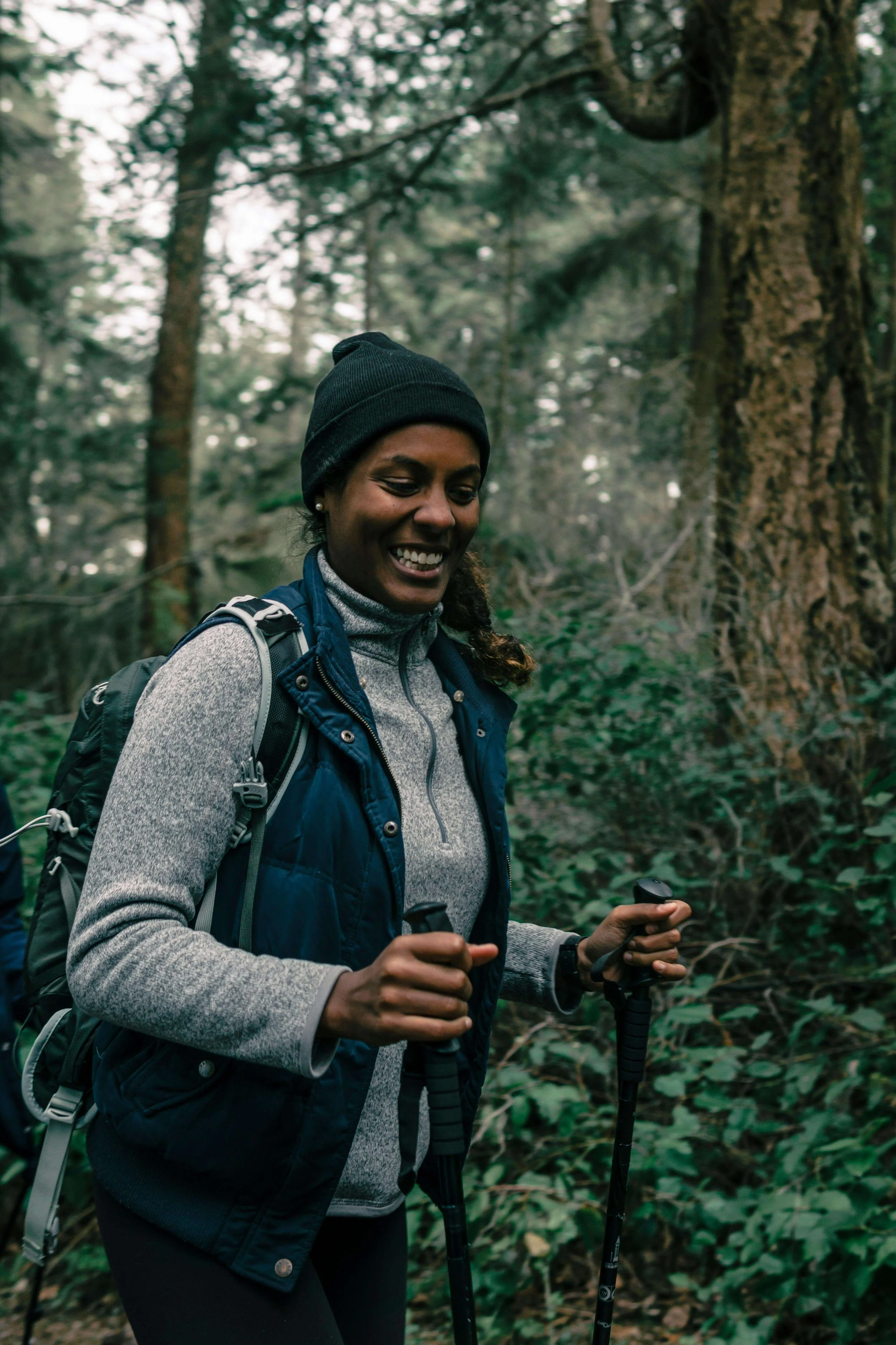 Woman smiling while hiking in forest, representing the freedom and joy of healing through religious therapy online St. Paul, MN, and LGBTQ therapy in St. Paul, MN.