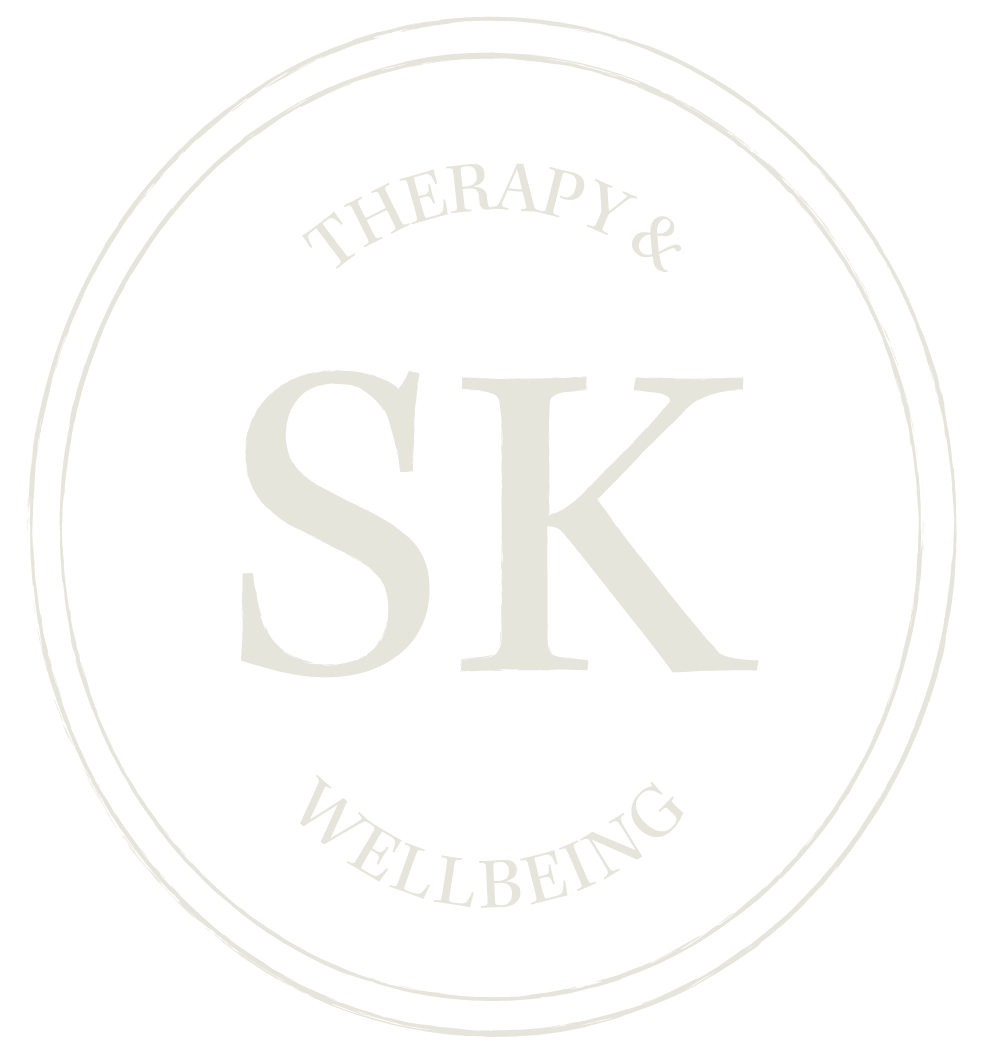 A black circular logo with white text that reads "THERAPY & WELLBEING" around the top and bottom, with the initials "SK" in the center.