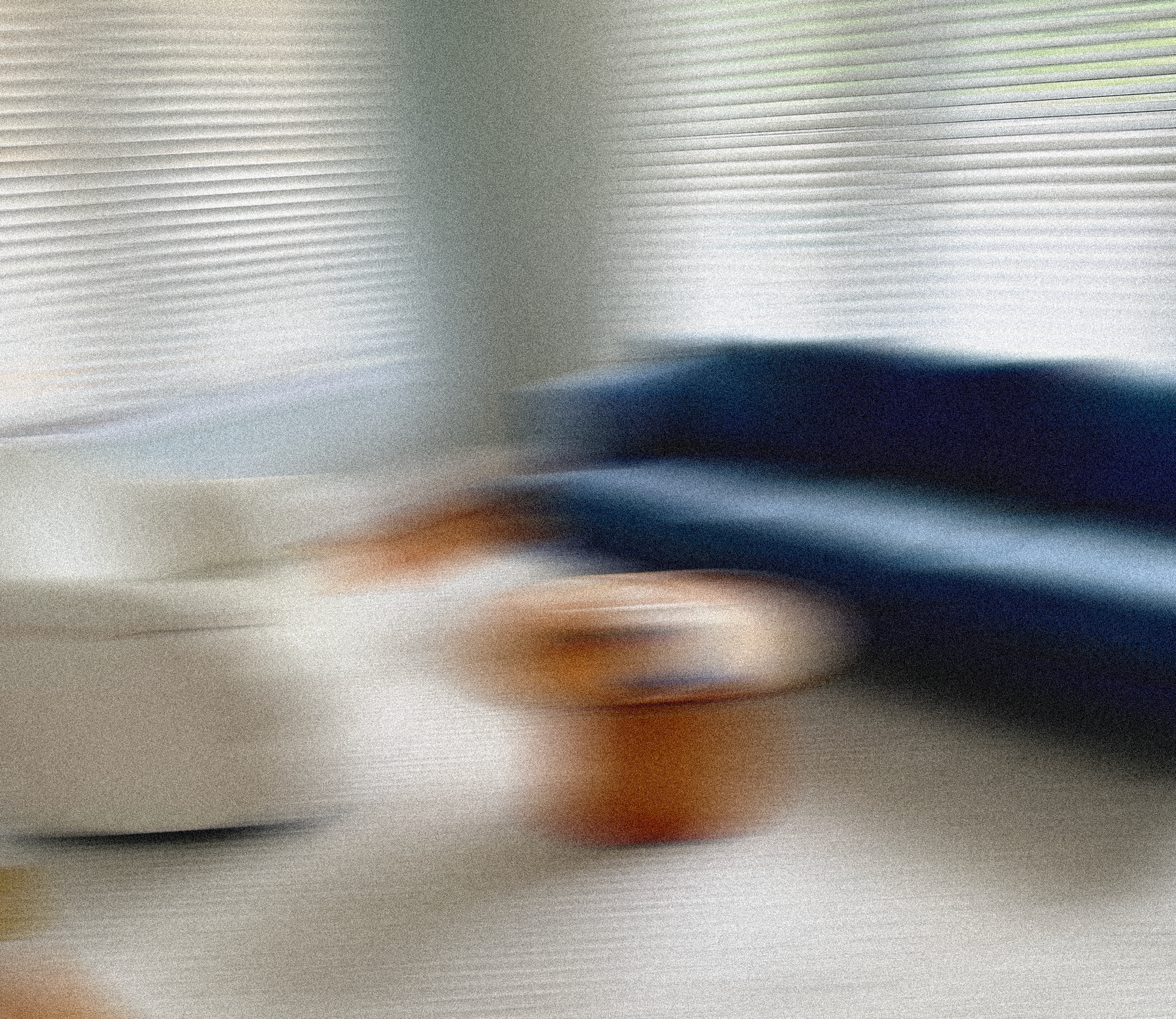Blurred image of a person in motion, with horizontal lines suggesting movement or an abstract scene.