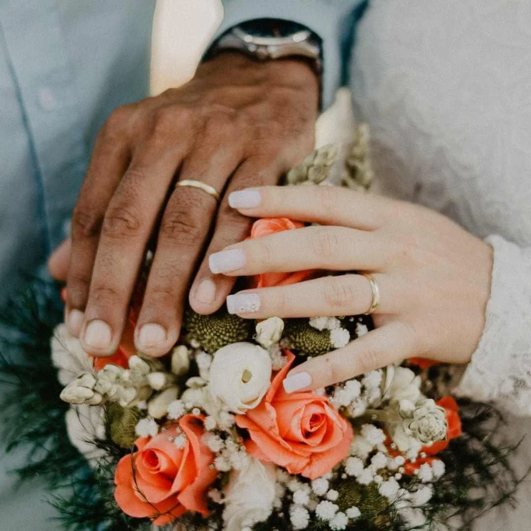 A bouquet of flowers with a couple holding it with wedding rings. This represents how Marcus Hunt Therapy has a couples therapist providing online couples therapy, relationship counseling through online therapy in Utah.