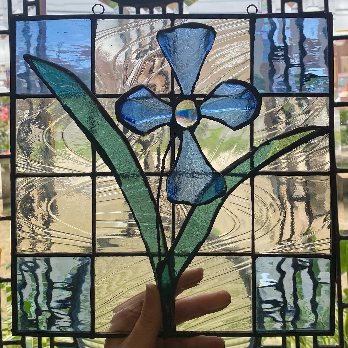 We completed this cute piece this week as part of a new garden series that we are working on👀🦋. Swipe to see one of our adorable assistants!

This piece has fused glass leaves and petals soldered onto a clear textured grid background to make it LIT