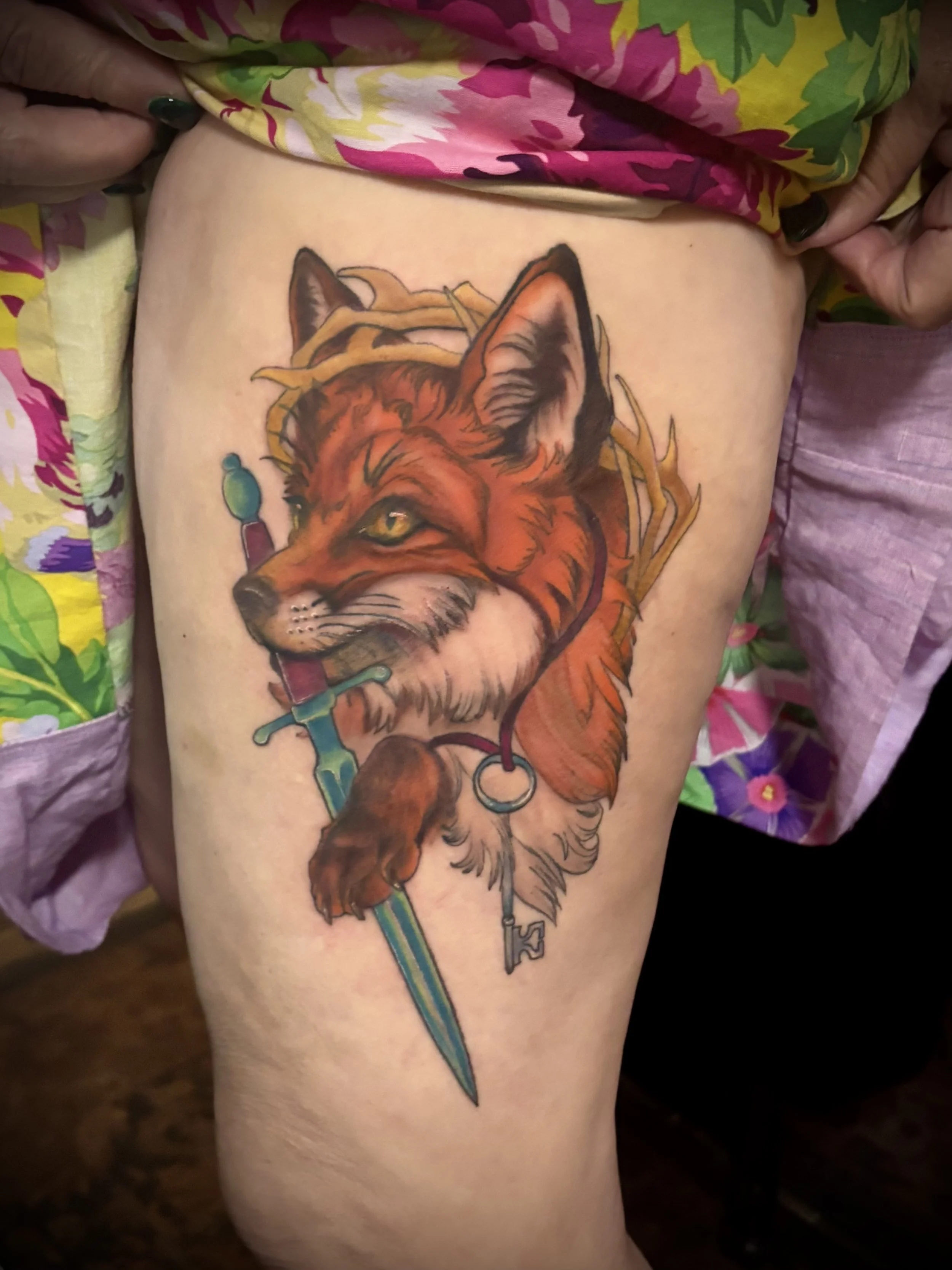 Tattoo of a Fox with sword, thorn branches, and key on a red ribbon around the fox neck