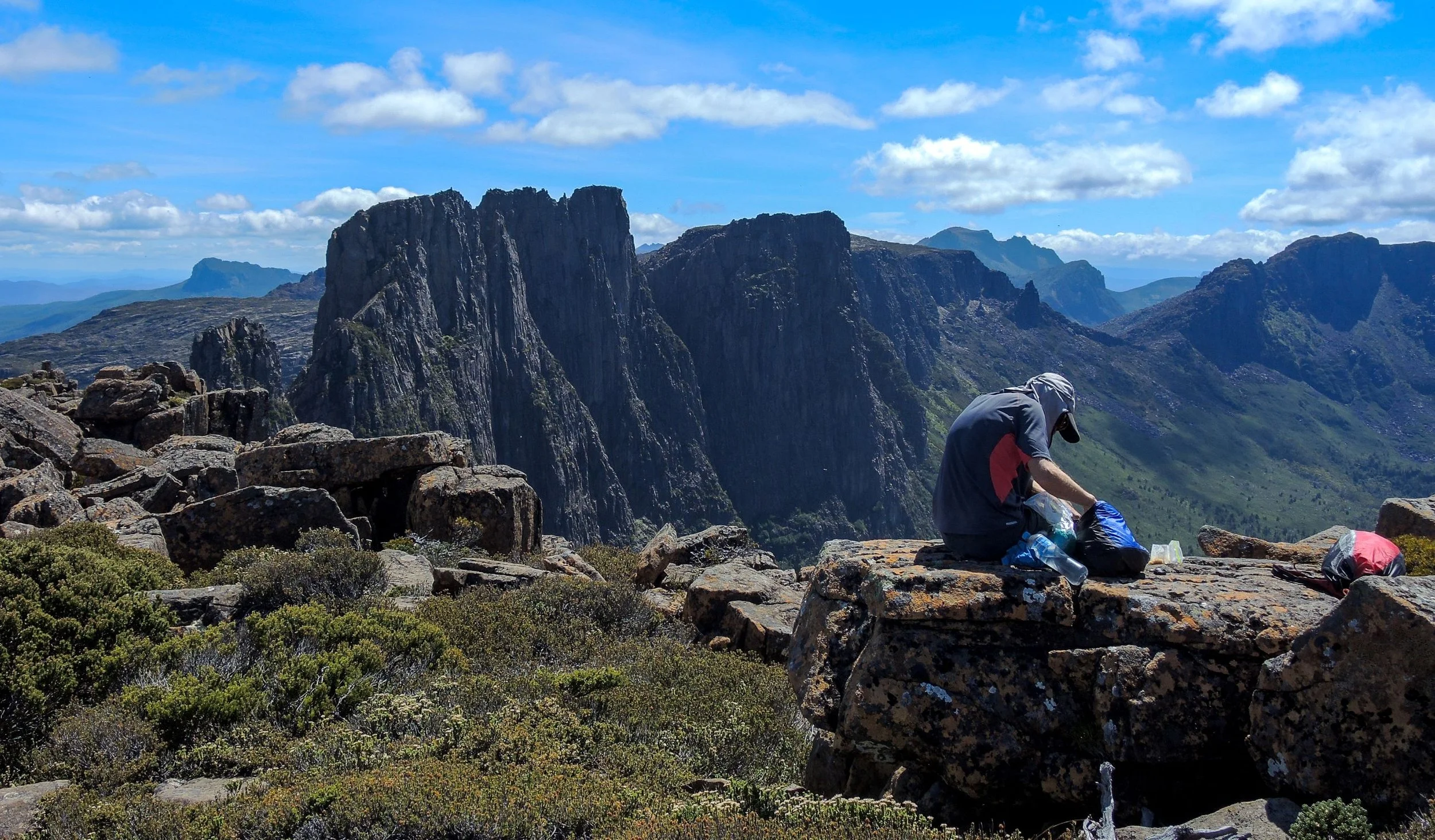 Hiker eating lunch on top of the acropolis Tasmania Australia