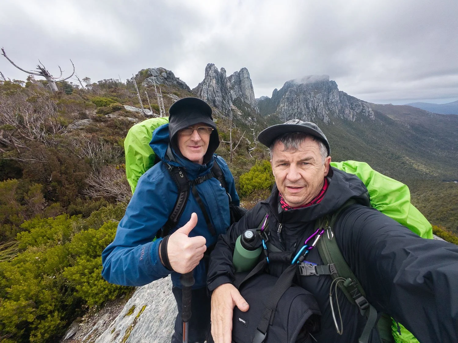two men in rain gear giving the thumbs up sign