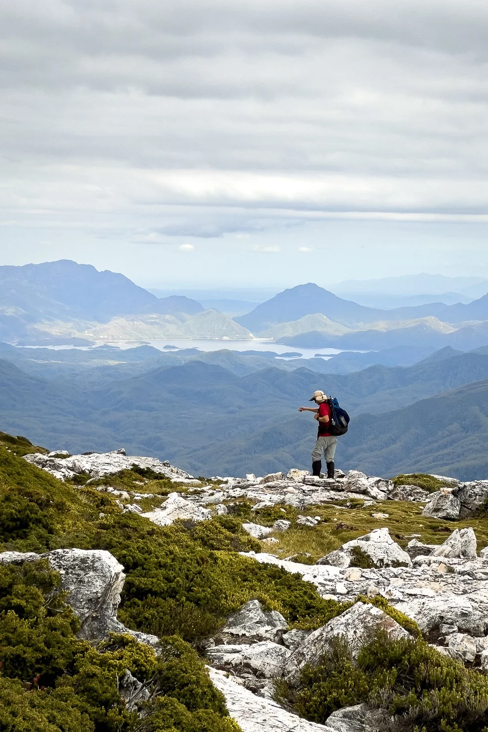 hiker on crest of mountain with vast views across wilderness