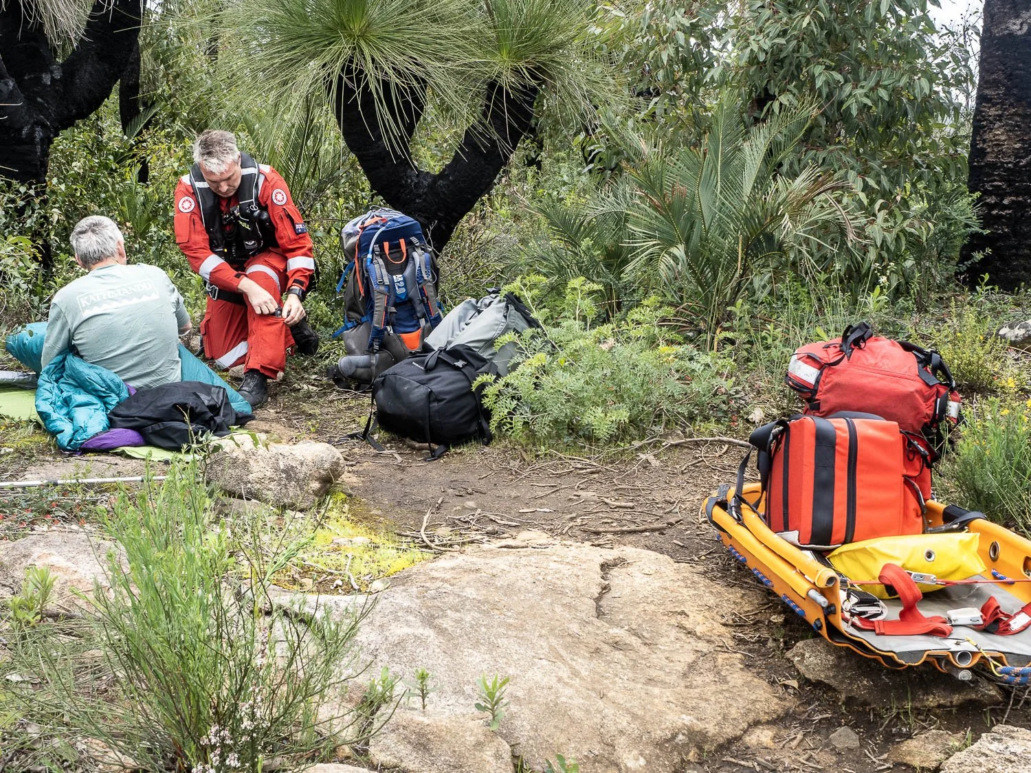 hiker being attended to by paramedic in forest