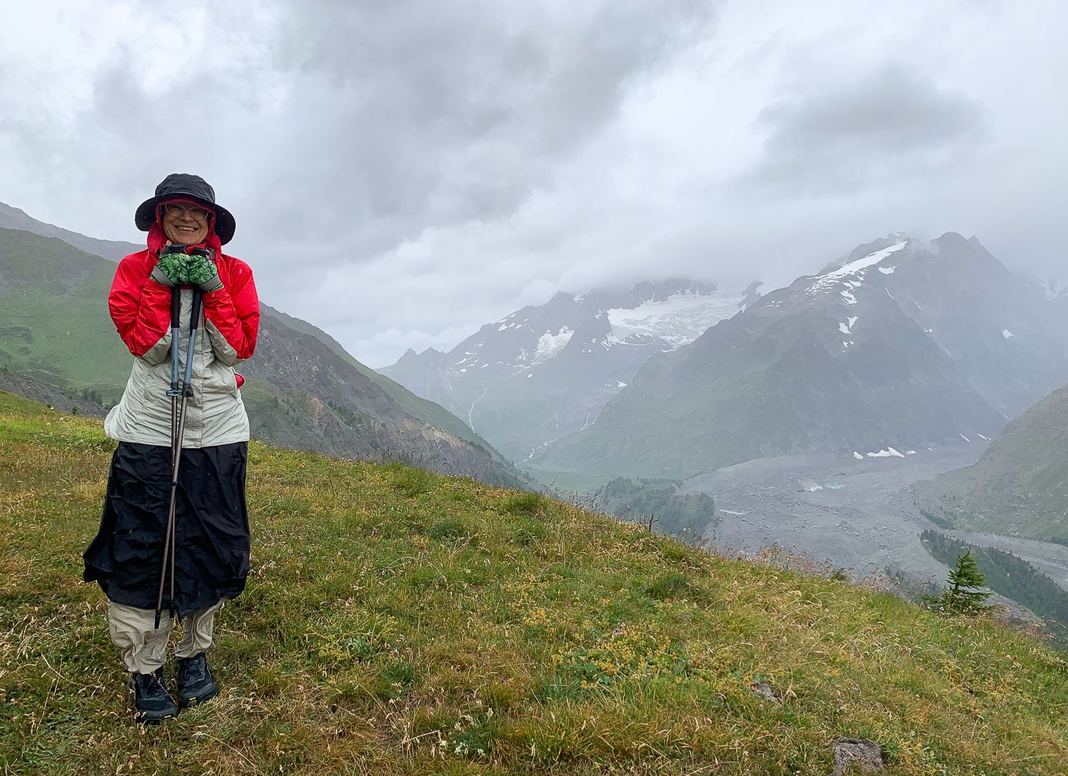 smiling hiker in rain kilt and jacket on hill side in mist