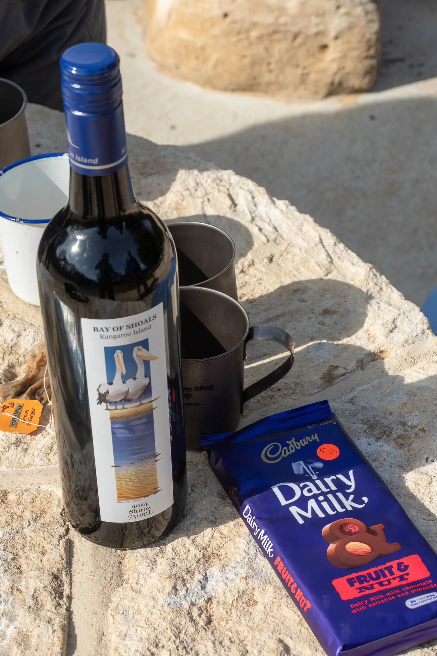 red wine and chocolate on park bench