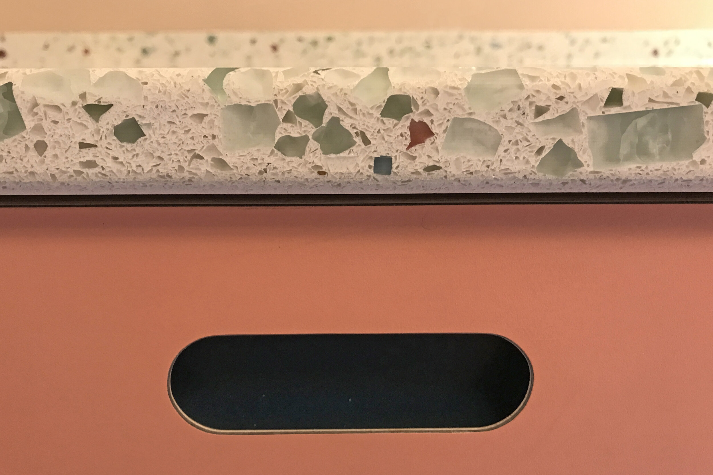 Beautiful hard wearing recycled glass worktops on this Ritzy pink kitchen by Pluck kitchens in Islington town house, London.
The kitchen also featured Atantic Blue cupboards and a beautiful kitchen larder. Close up detail of finger pull detail handle