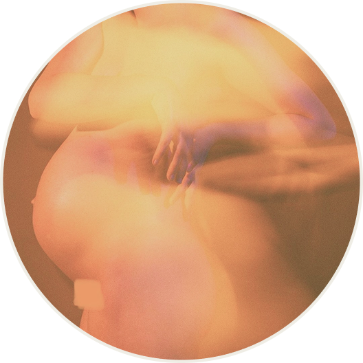 orange and pink image of a pregnant person, there is a slight blurry effect making the person unrecognizable