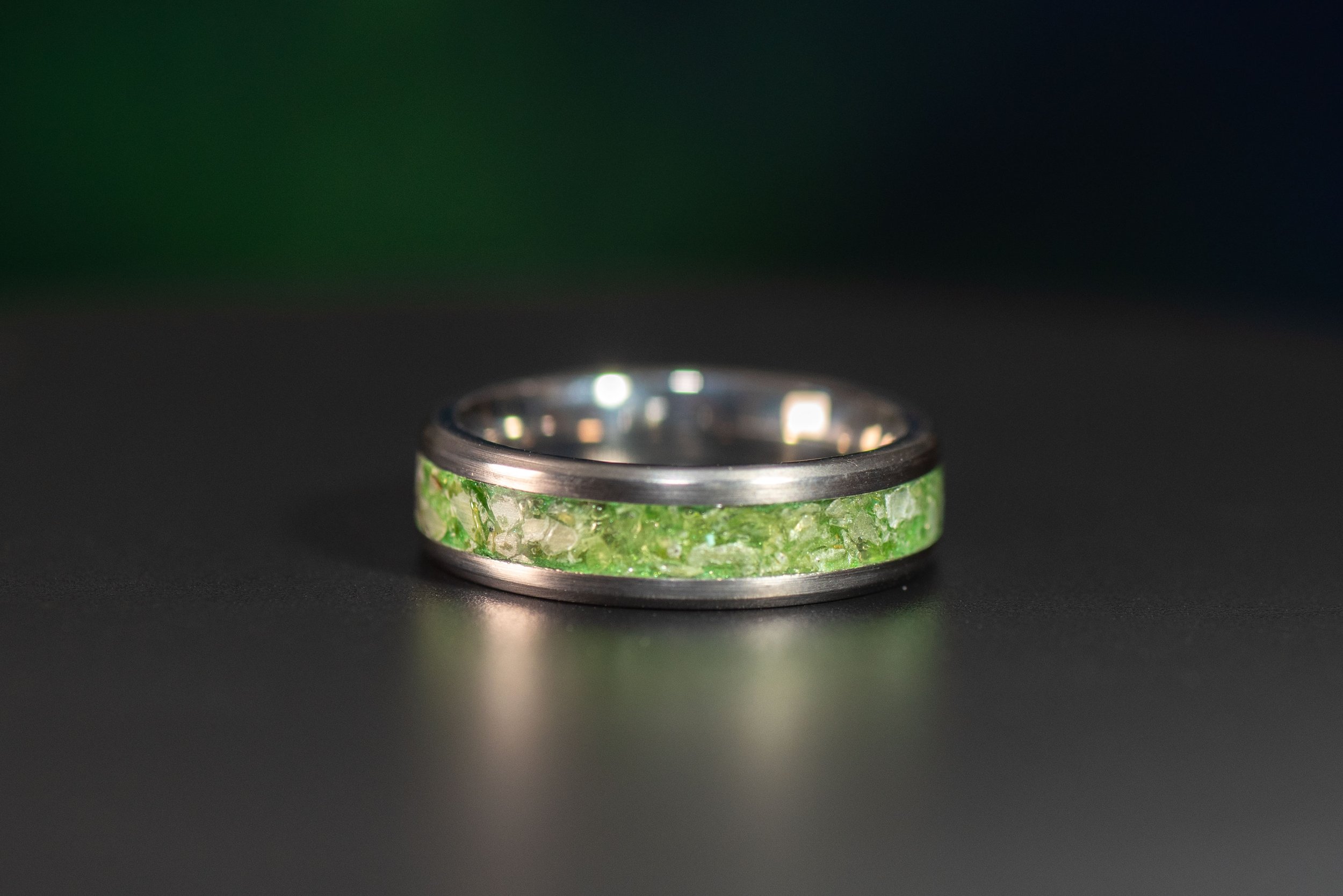 Handcrafted titanium ring with a vibrant peridot inlay, perfect as an August birthstone ring.