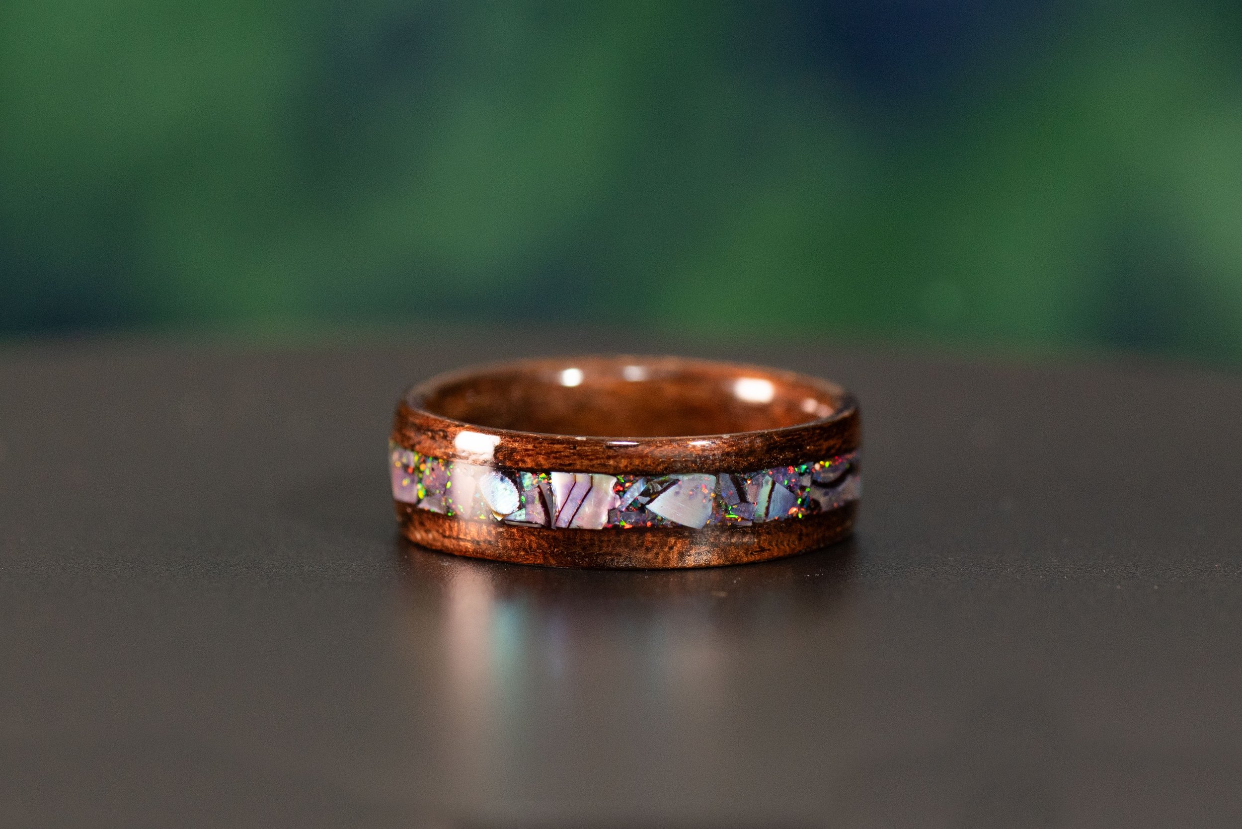 smoked rosewood with abalone and black opal inlay. solid wood ring