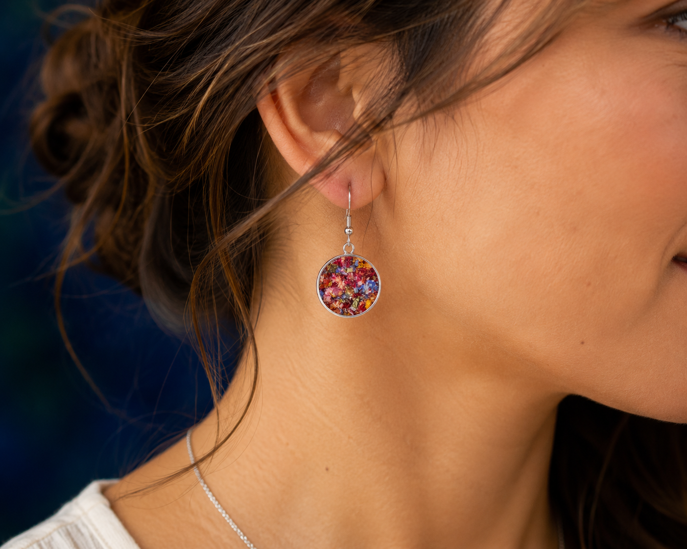 Woman wearing sterling silver flower preservation earrings made from preserved wedding bouquet flowers