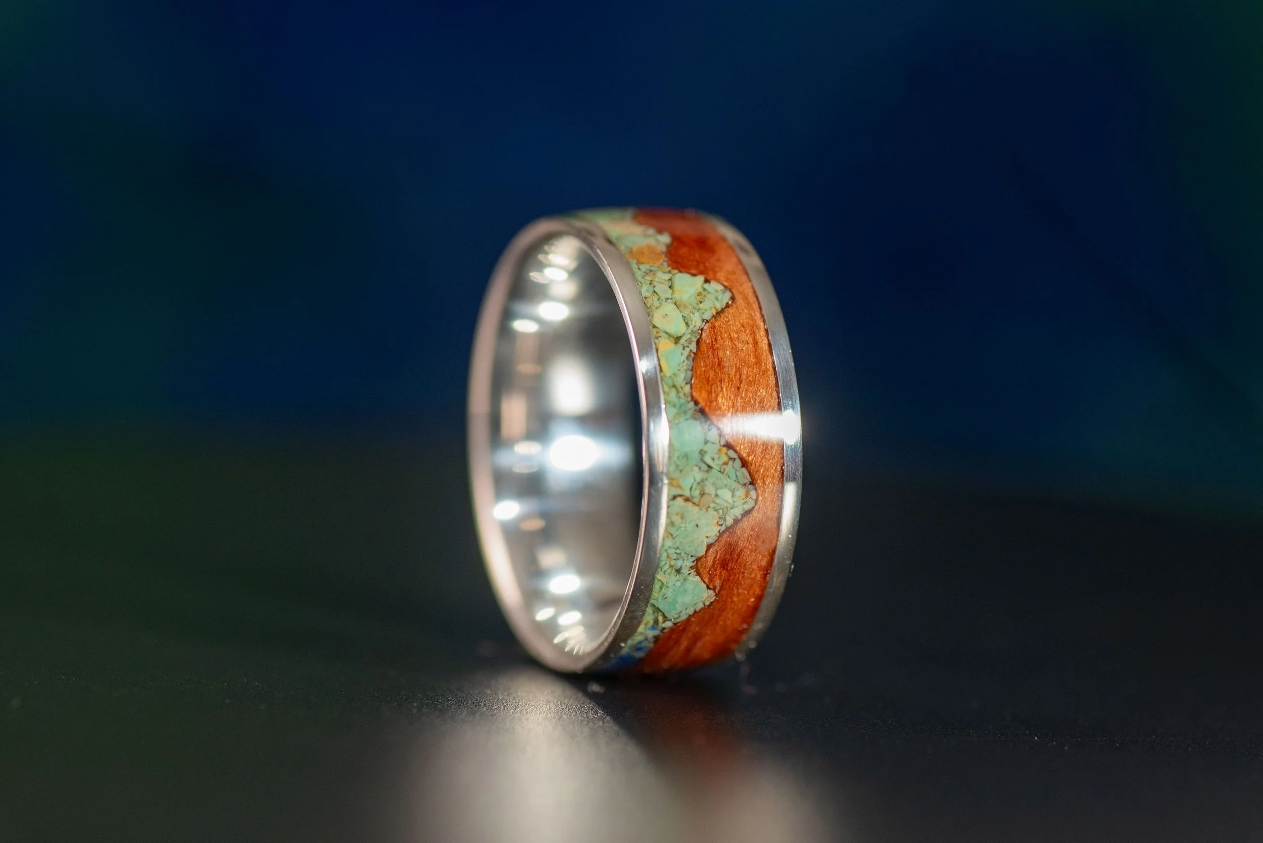 Six-millimeter and eight-millimeter sterling silver mountain rings with redwood and Sonoran turquoise inlay.