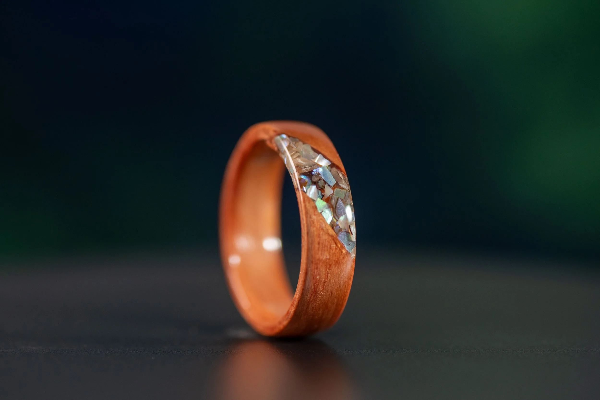 Handmade abalone and redwood ring with customizable core, coastal inspired wood wedding band.
