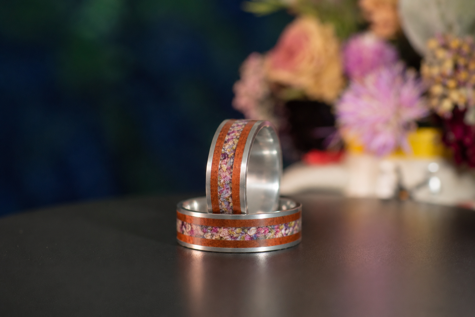 Handcrafted flower preservation ring featuring warm mahogany wood, polished sterling silver, and a custom floral center stripe.