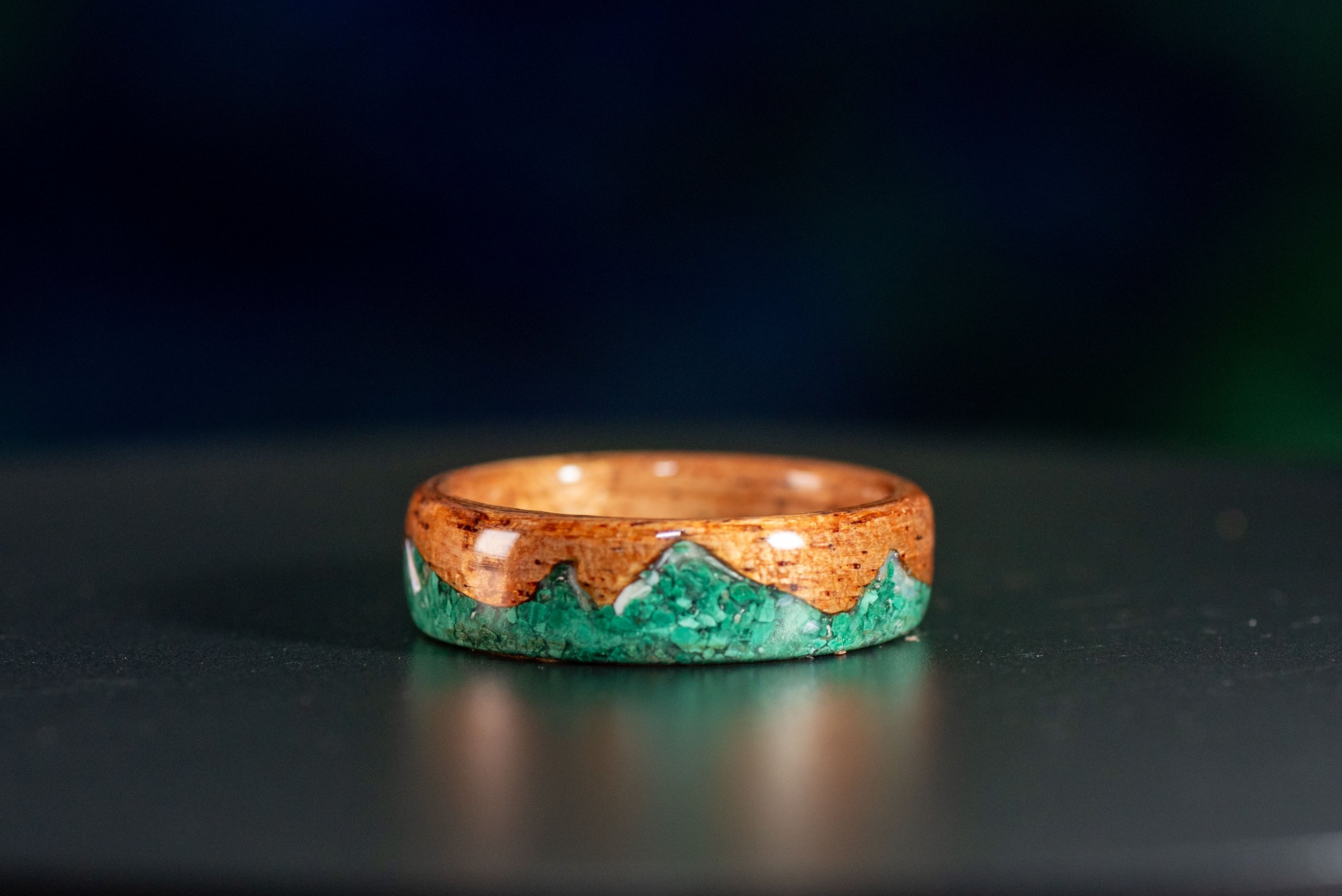 Nature inspired wood ring featuring green malachite mountains and snowy pearl peaks