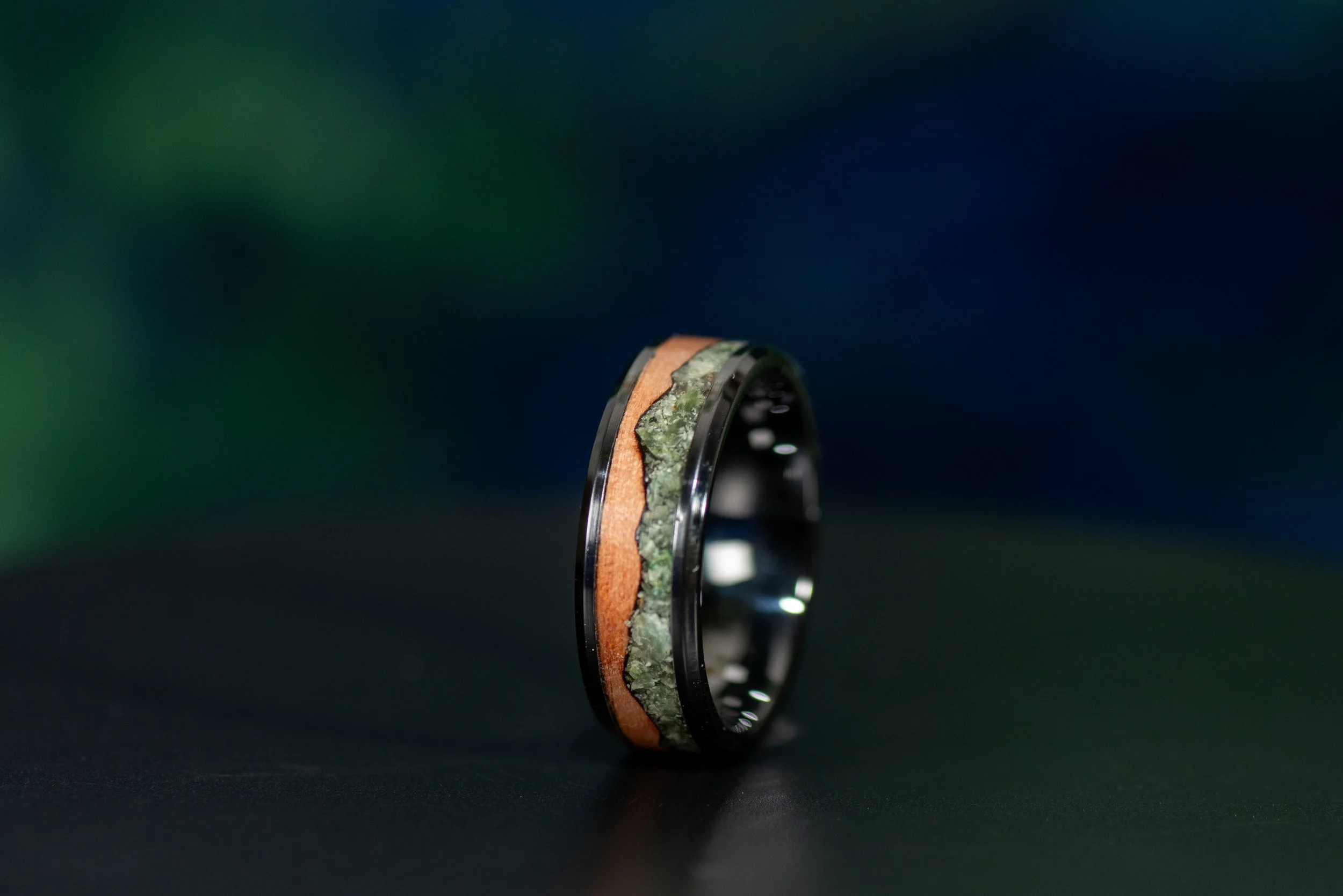 Men’s mountain ring featuring black ceramic, natural tineo wood and jade gemstone inlay.