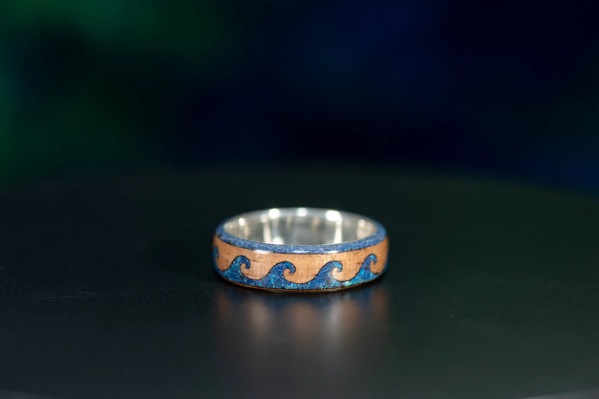 Walnut wood wave ring with lapis lazuli and shattuckite gemstone inlay inspired by the ocean.