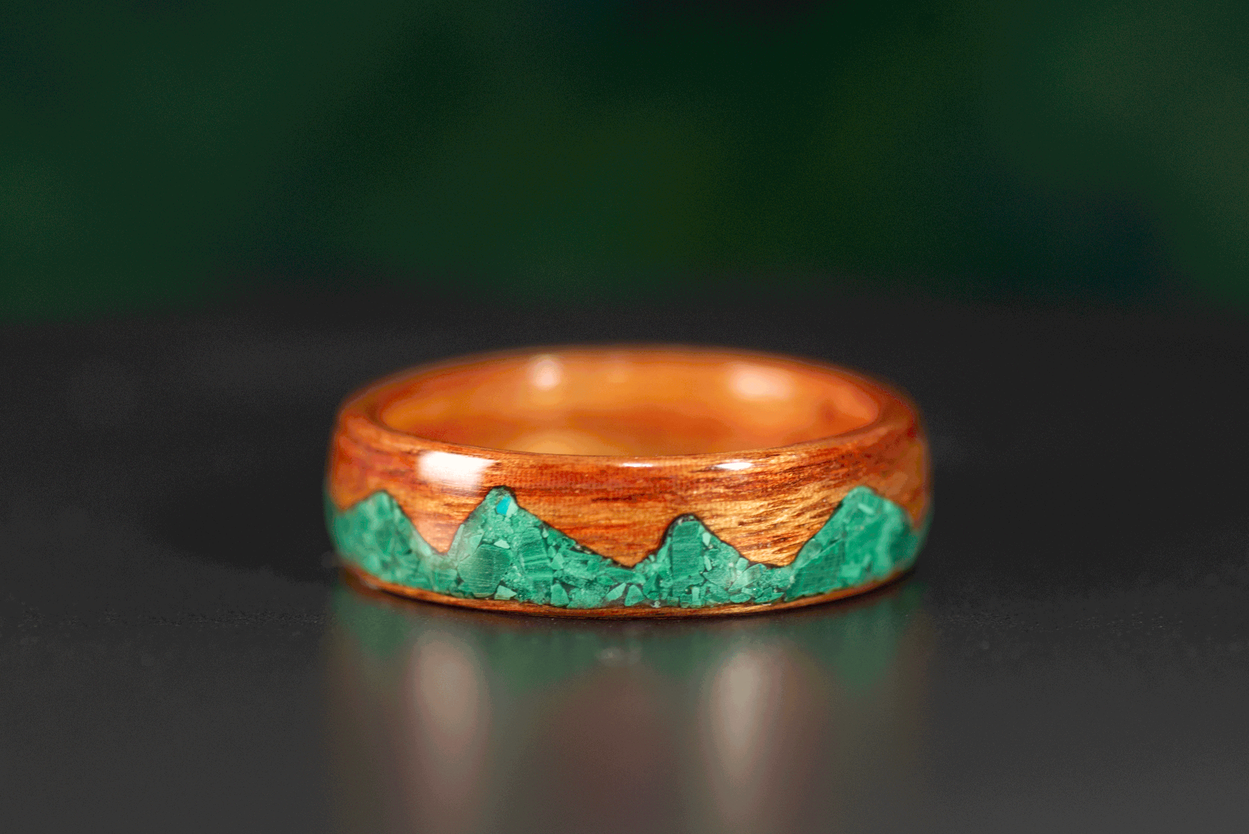 Handcrafted tineo wood ring featuring malachite mountain design