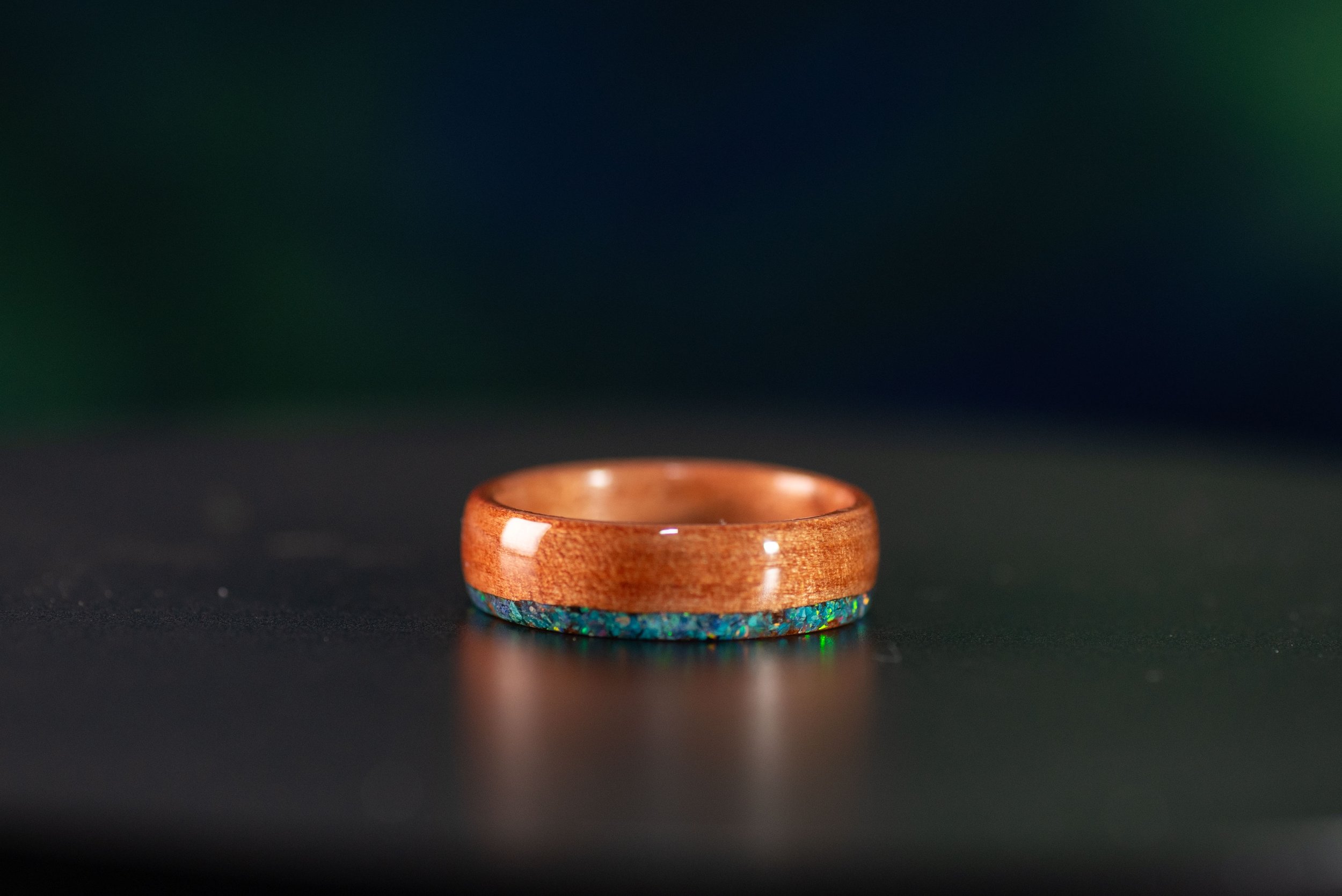 backside of Nature inspired wood ring featuring ocean wave design with bright stone inlays