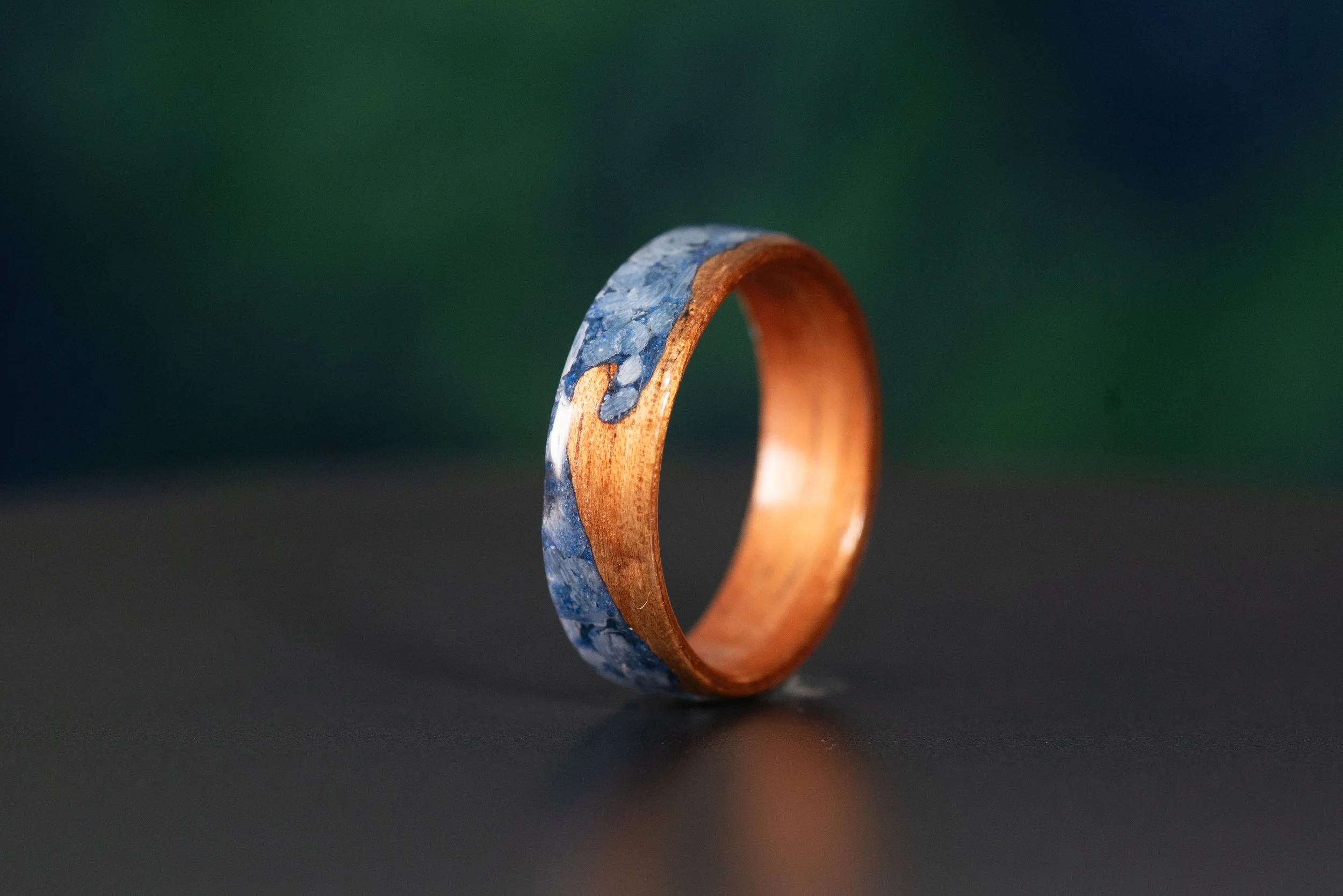 Ocean inspired koa wood ring featuring a wave design with blue coral and lapis lazuli.
