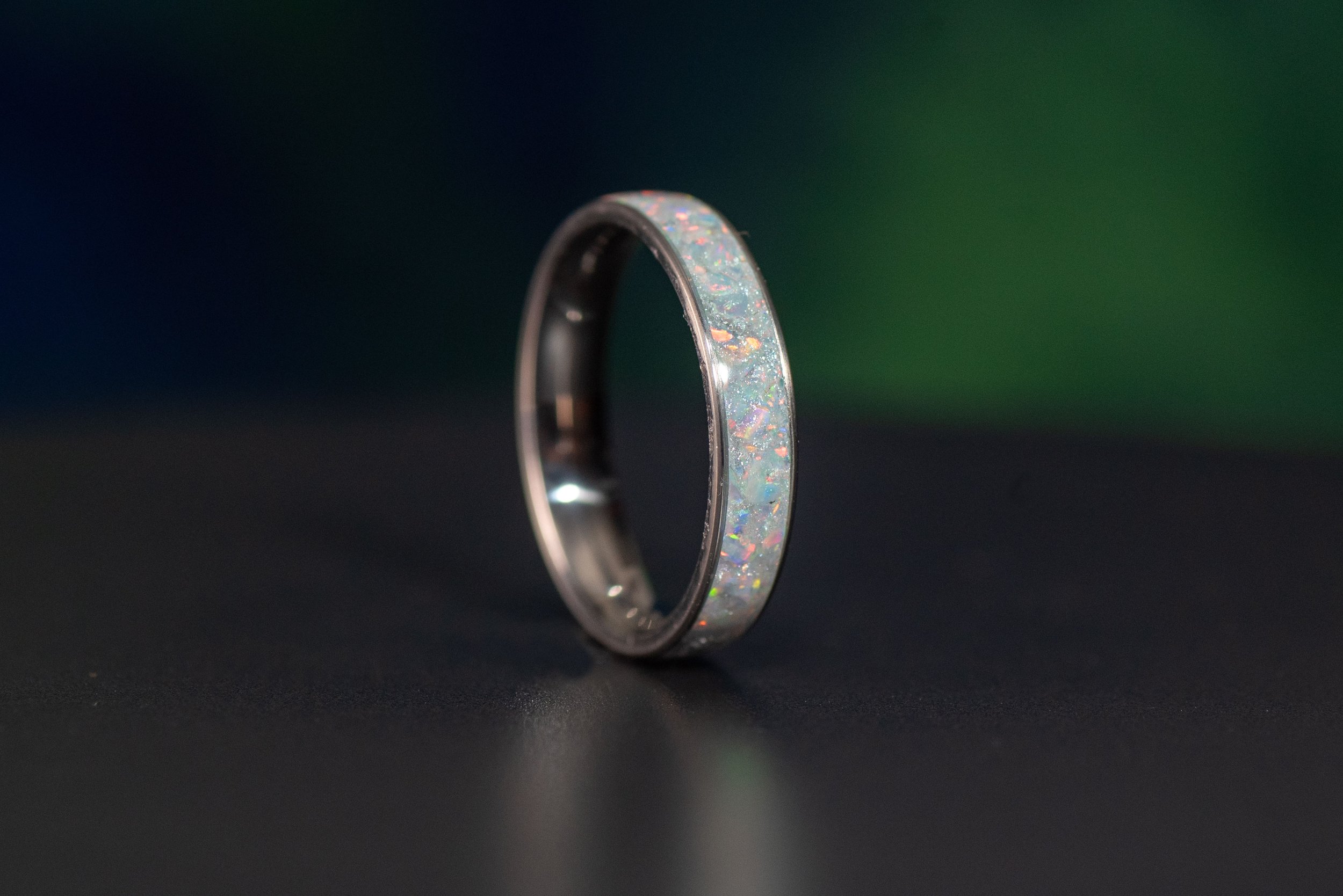 Unique opal titanium ring with shimmering hues, a lightweight and durable birthstone wedding band.