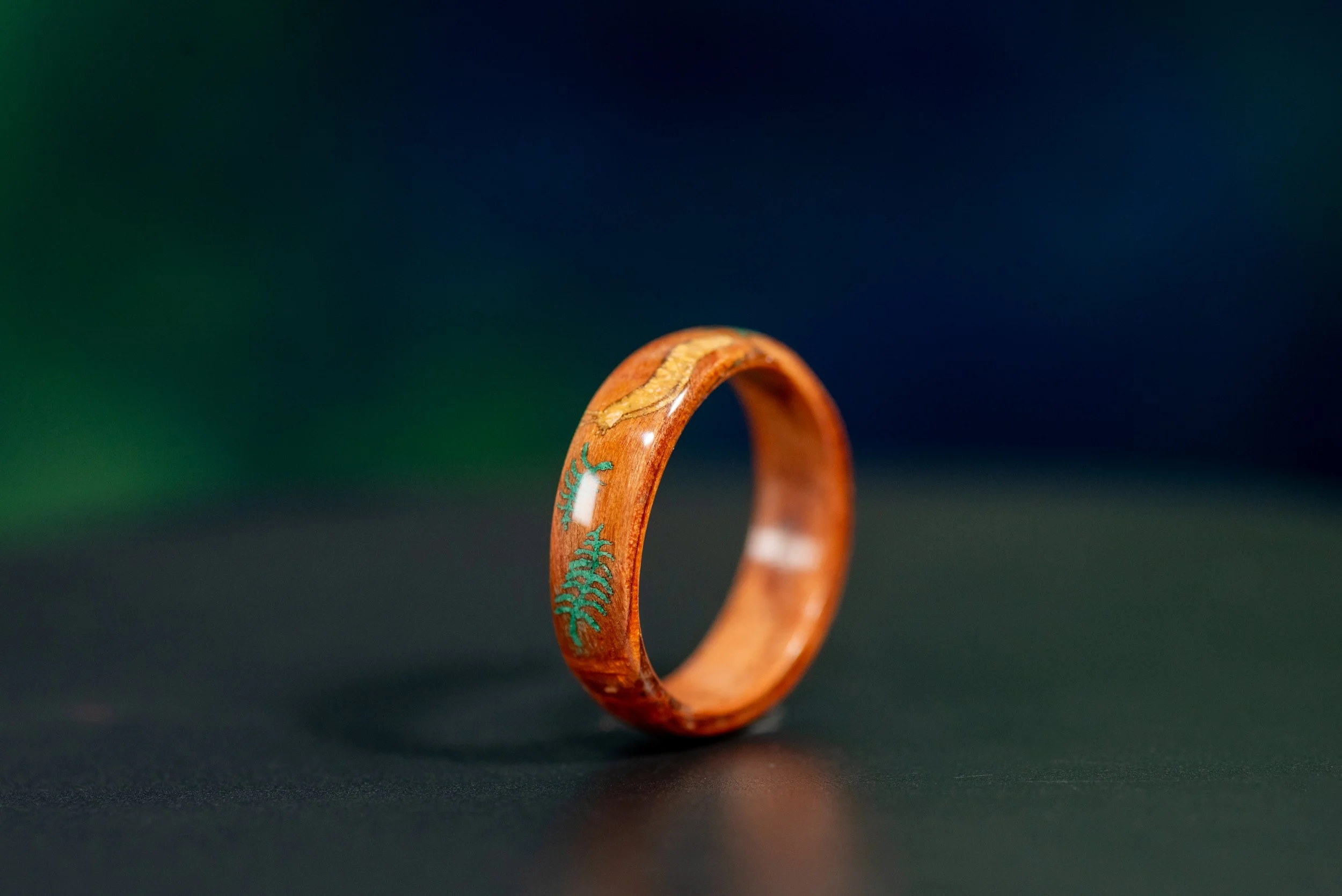 California redwood ring featuring a banana slug made from yellow jasper and a green malachite fern inlay.