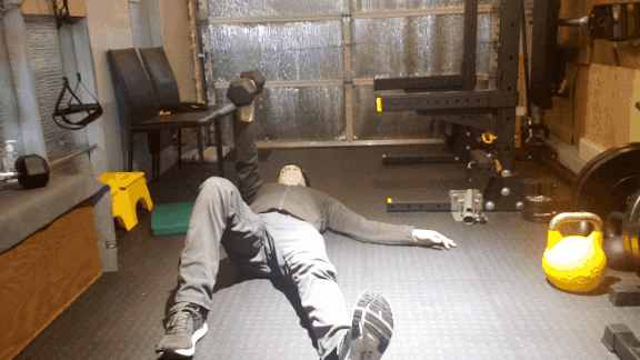 Personal trainer demonstrating a half Turkish get-up in a private strength training studio in SE Portland, Oregon.
