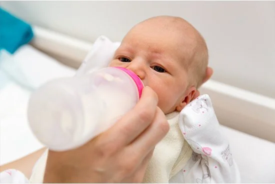 infant being fed by bottle