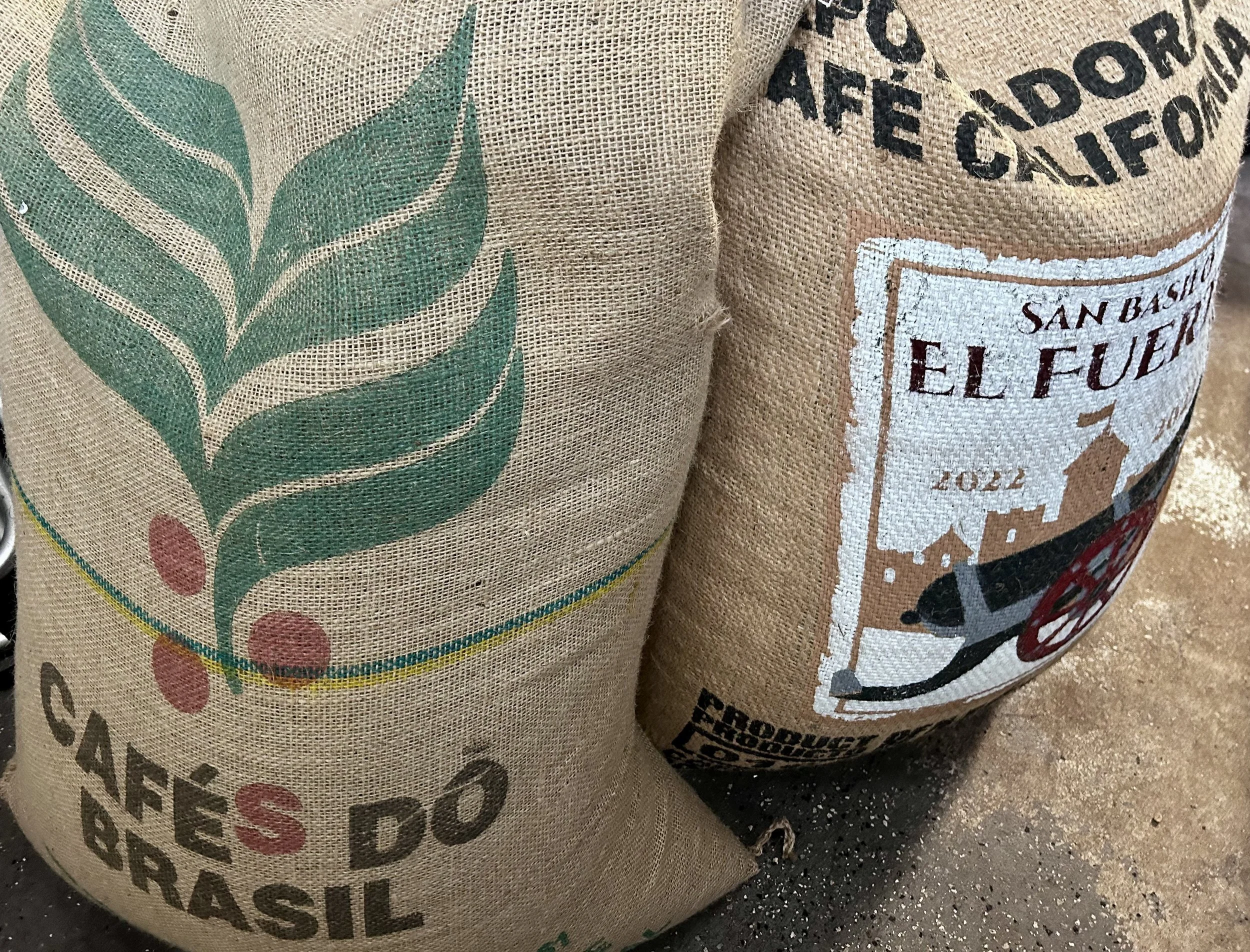 Burlap sacks of green coffee beans sourced for small-batch roasting by a New Jersey coffee roaster